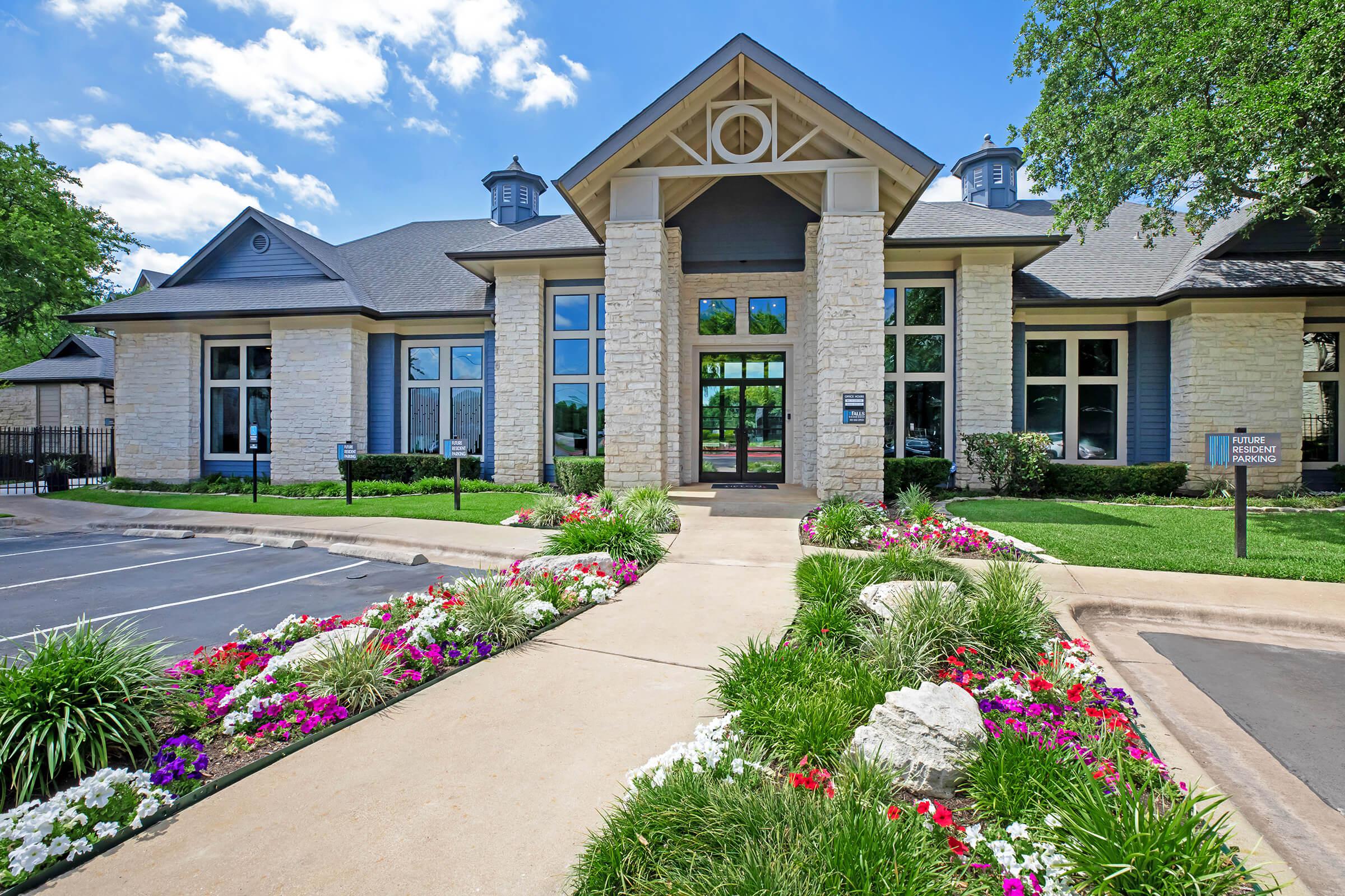 a close up of a flower garden in front of a house
