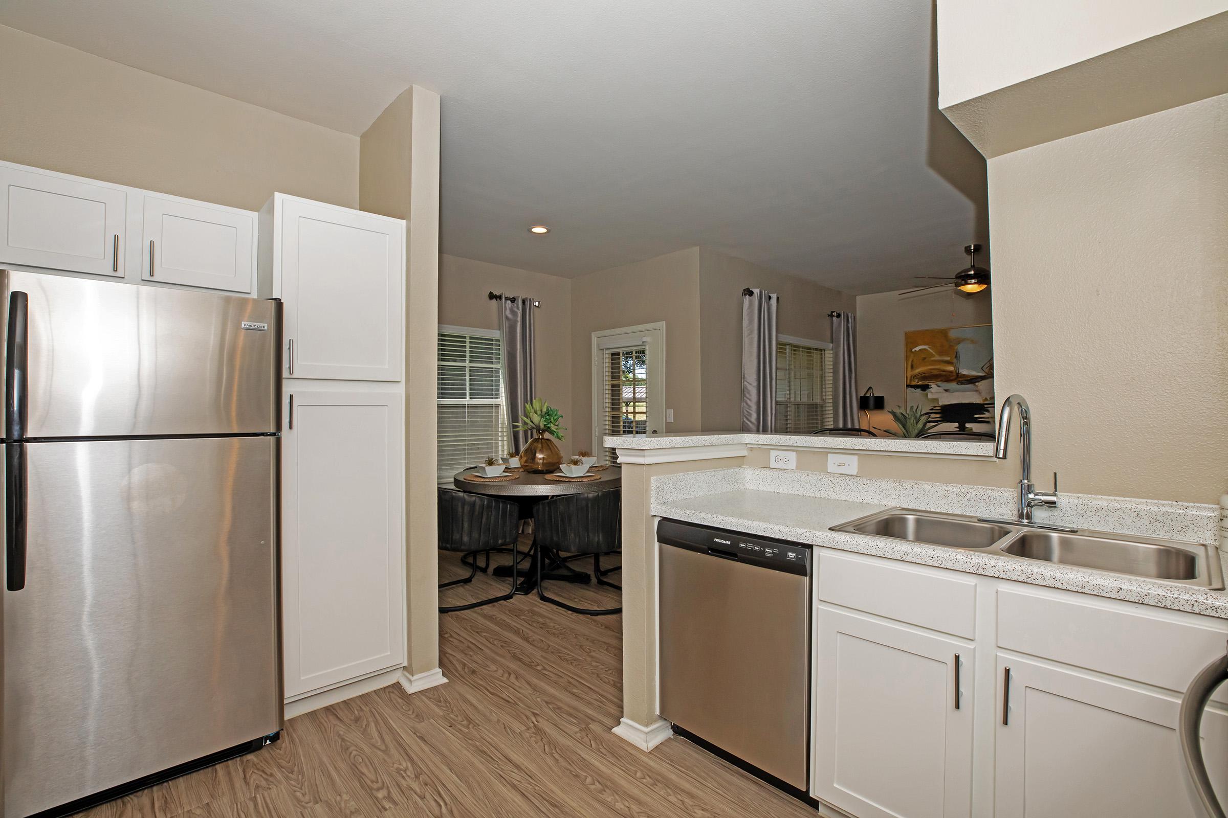 a furnished kitchen with white cabinets