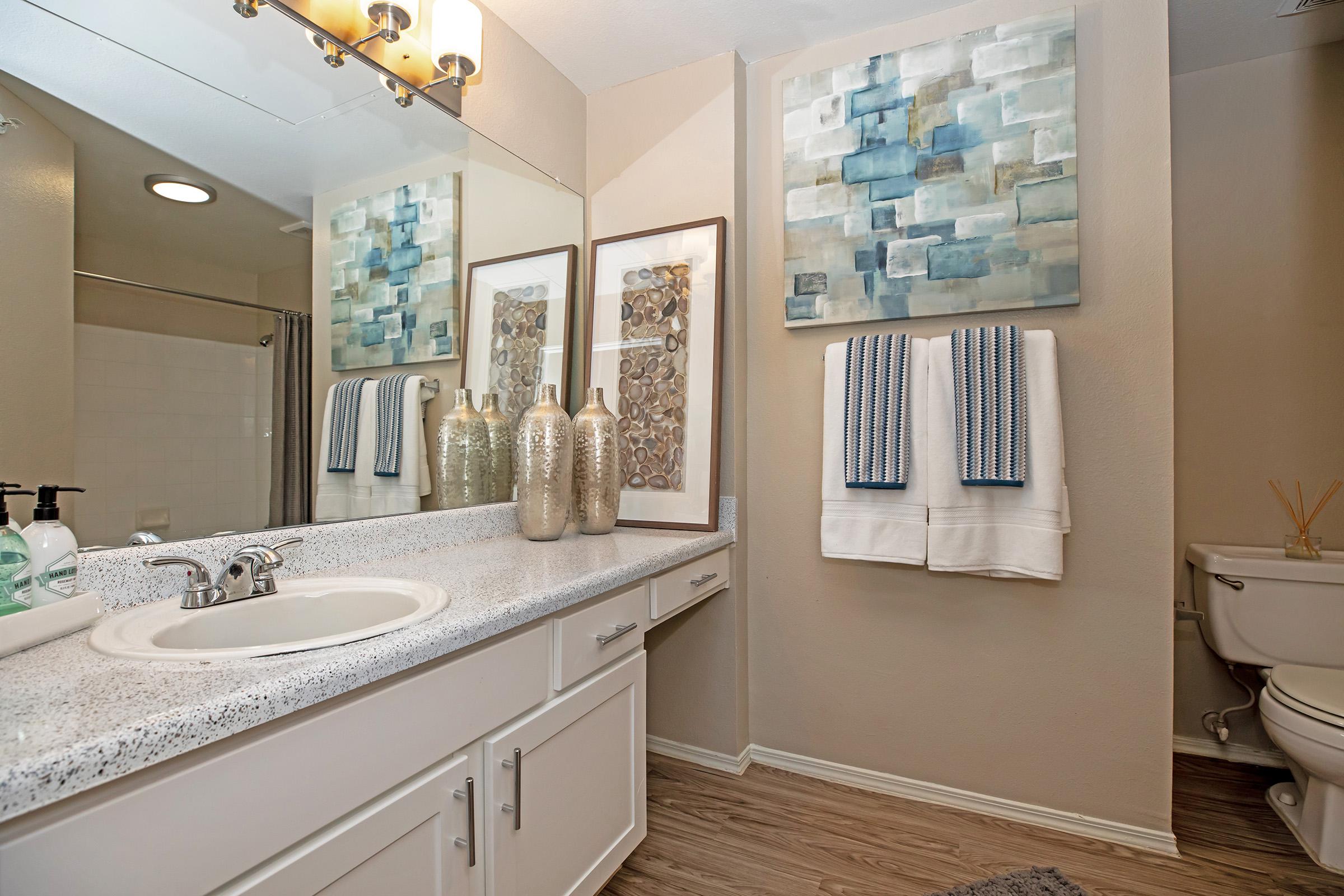 a furnished bathroom with white cabinets