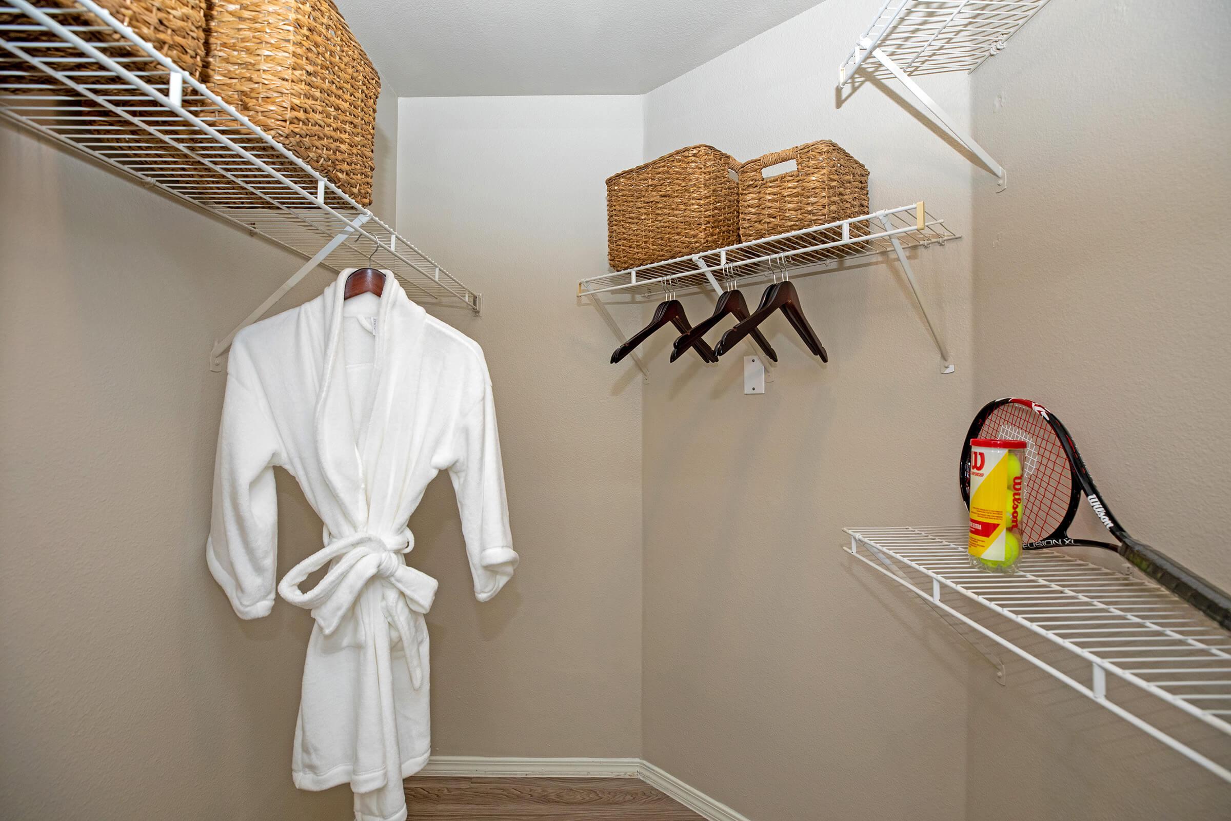 a furnished walk-in closet with wicker boxes