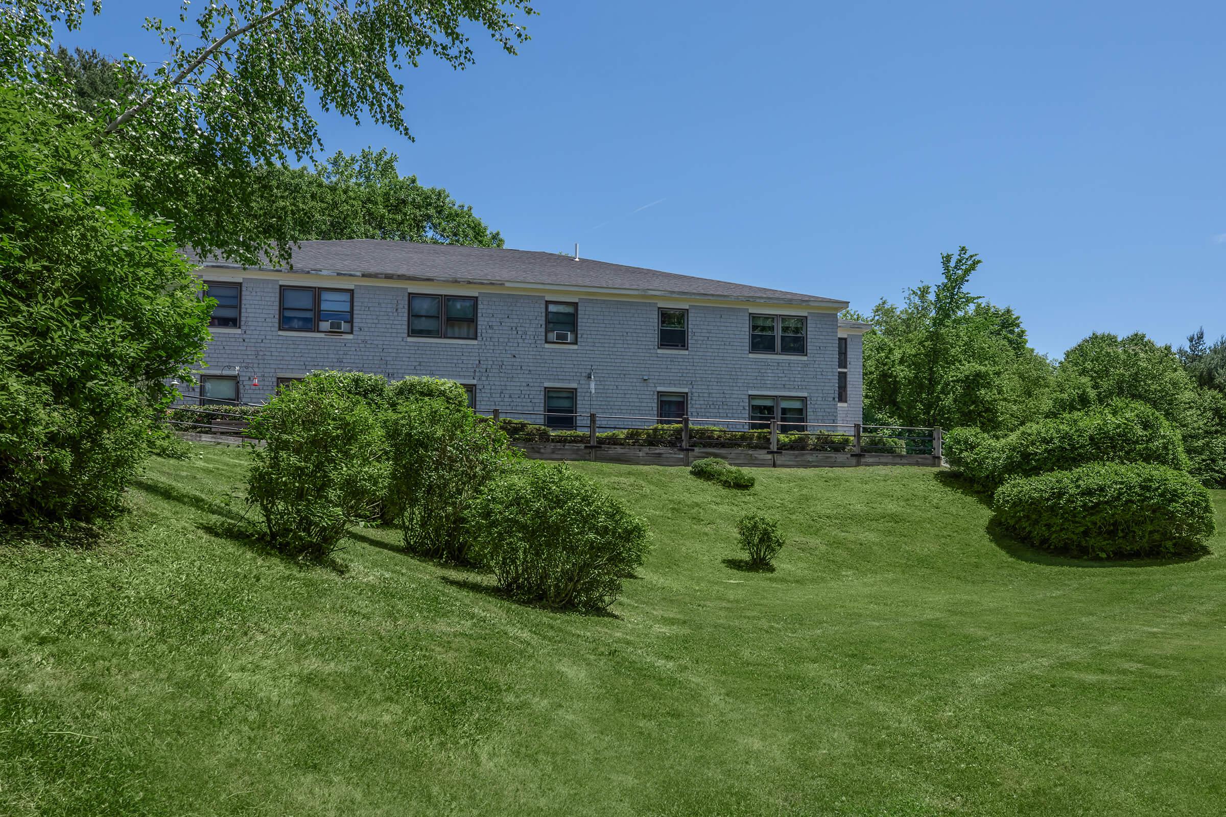 a large green field in front of a house