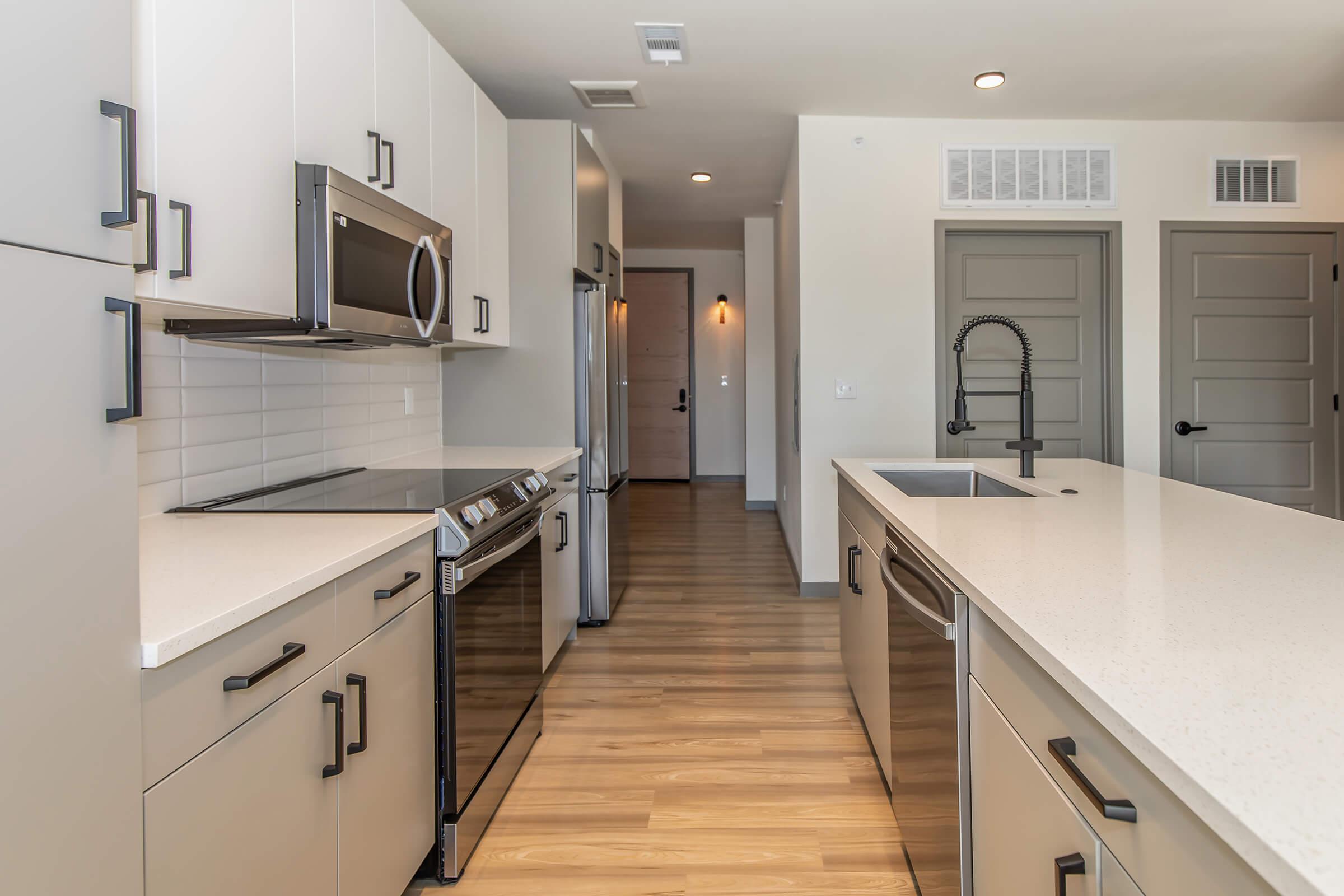 a modern kitchen with stainless steel appliances and wooden cabinets