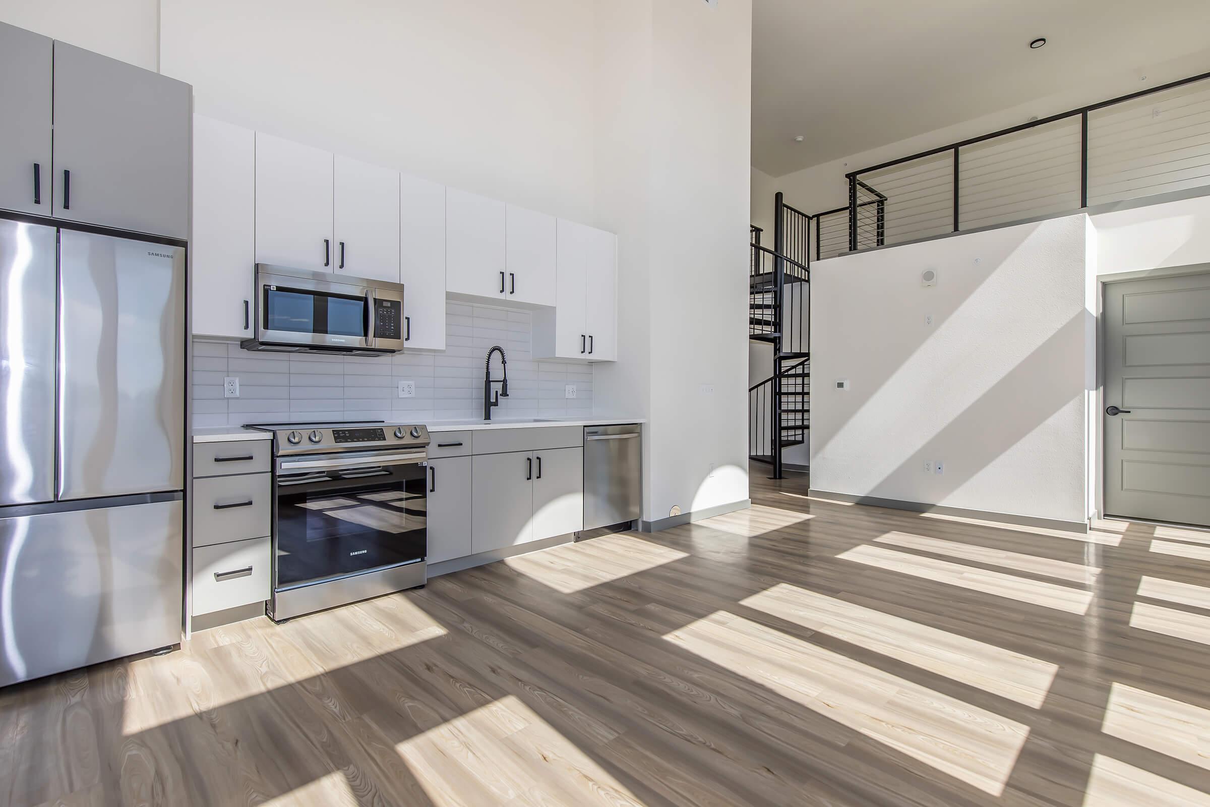 a large kitchen with stainless steel appliances and wooden cabinets