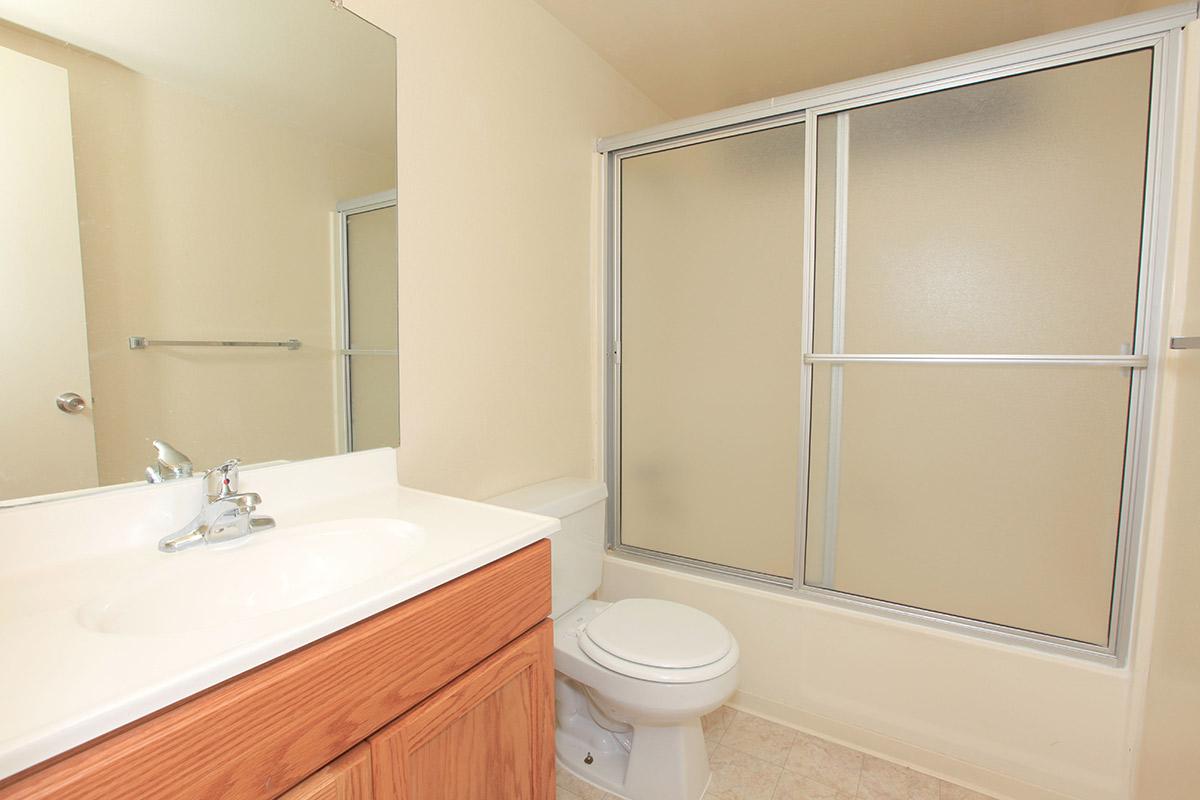 a white sink sitting next to a shower