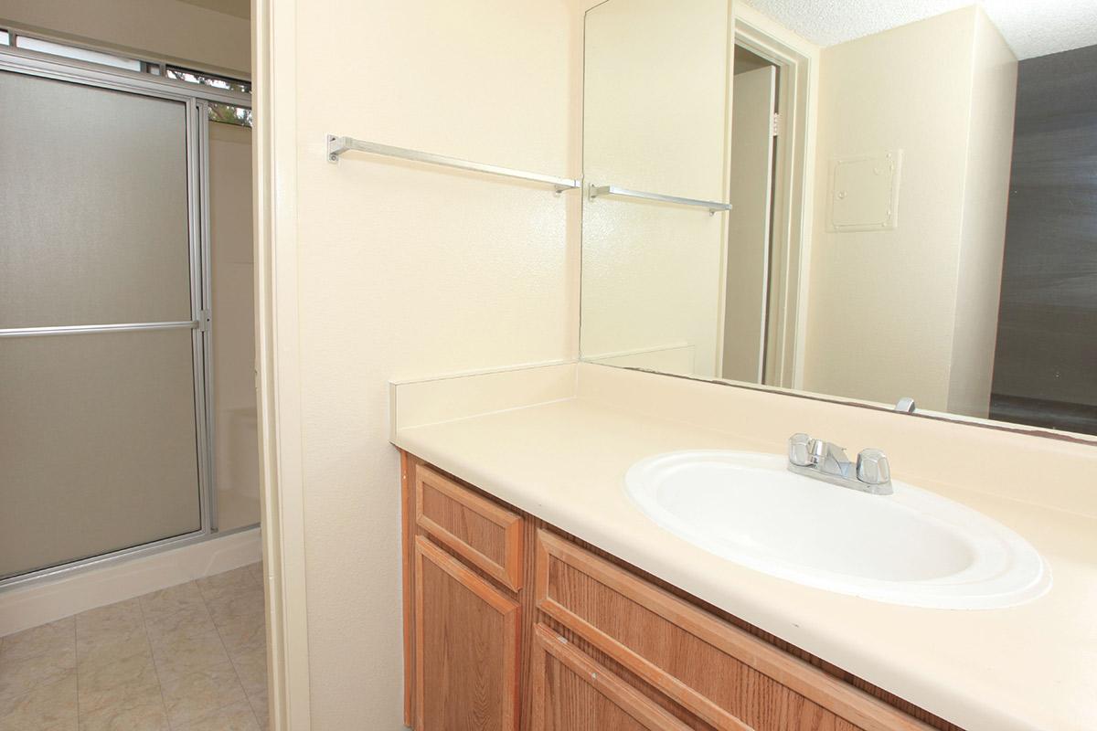 a white sink sitting under a mirror