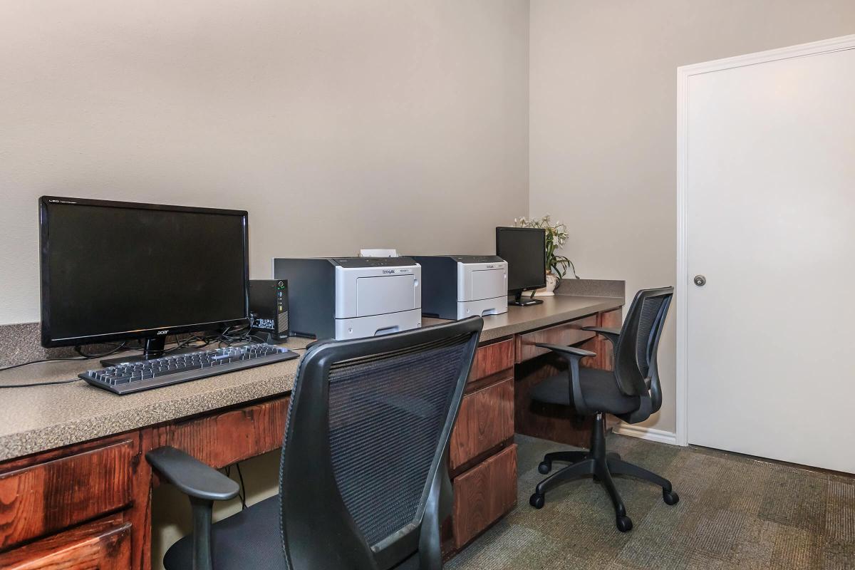 a desk with a computer and a chair in a room