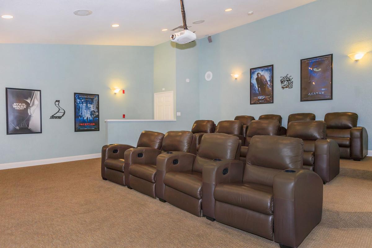 a living room filled with furniture and a large screen