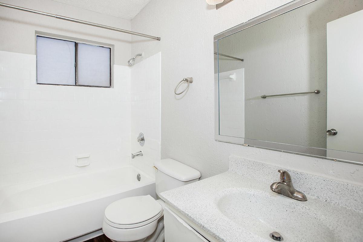 a white sink sitting under a mirror