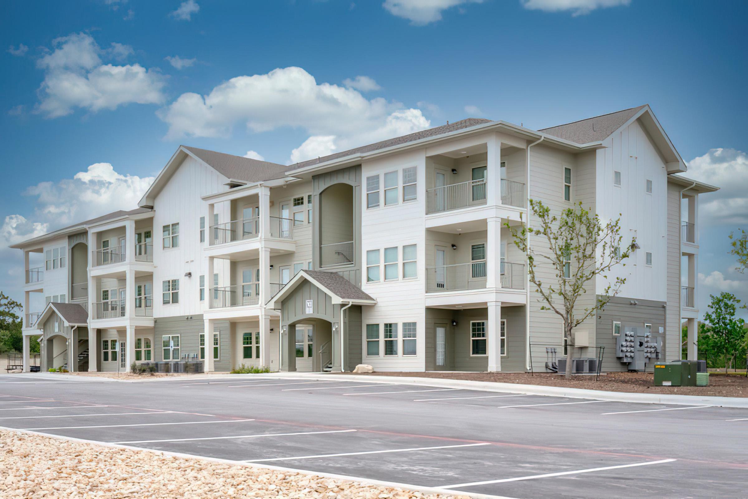 an empty parking lot in front of a house