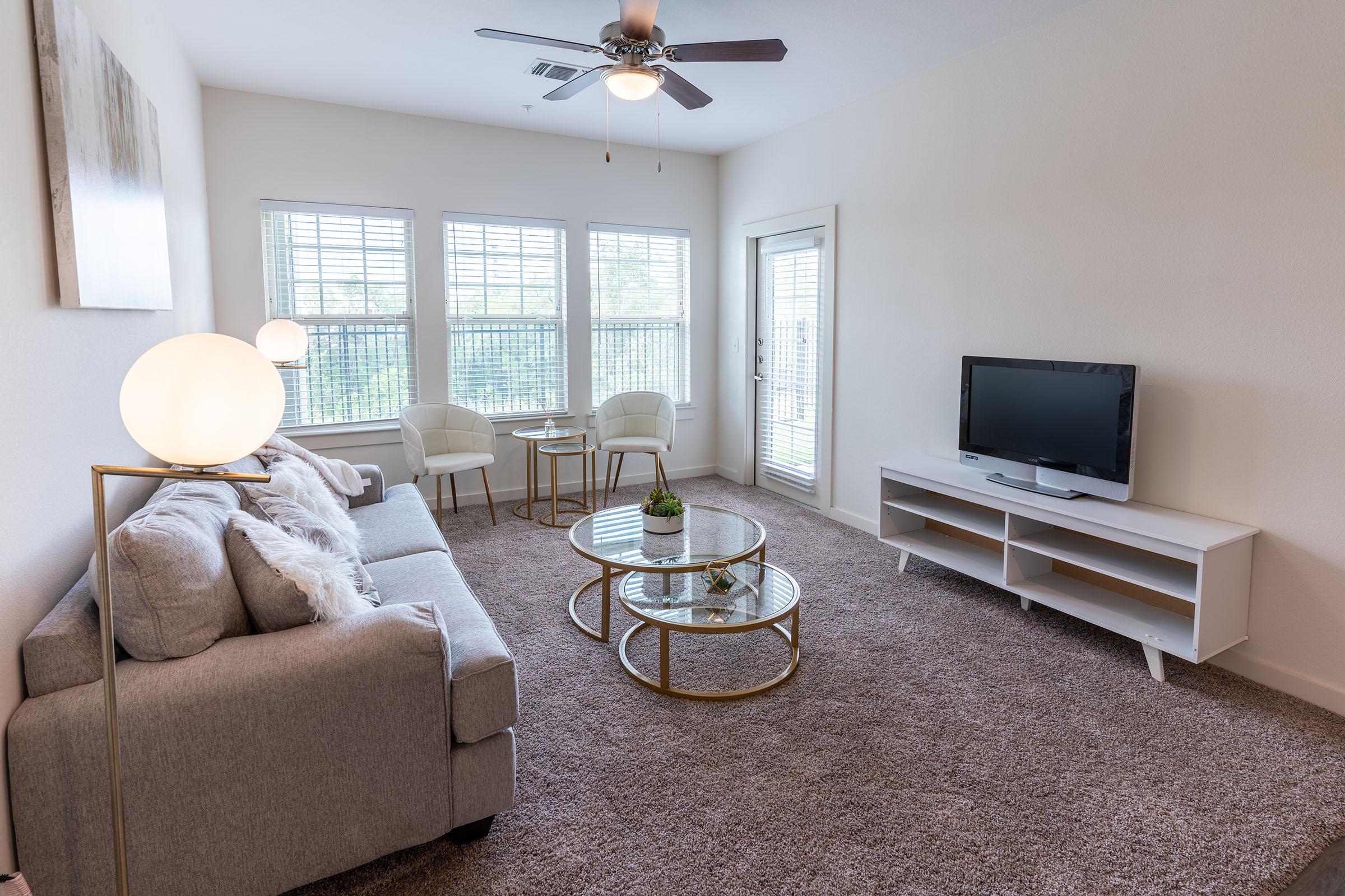 a living room filled with furniture and a large window