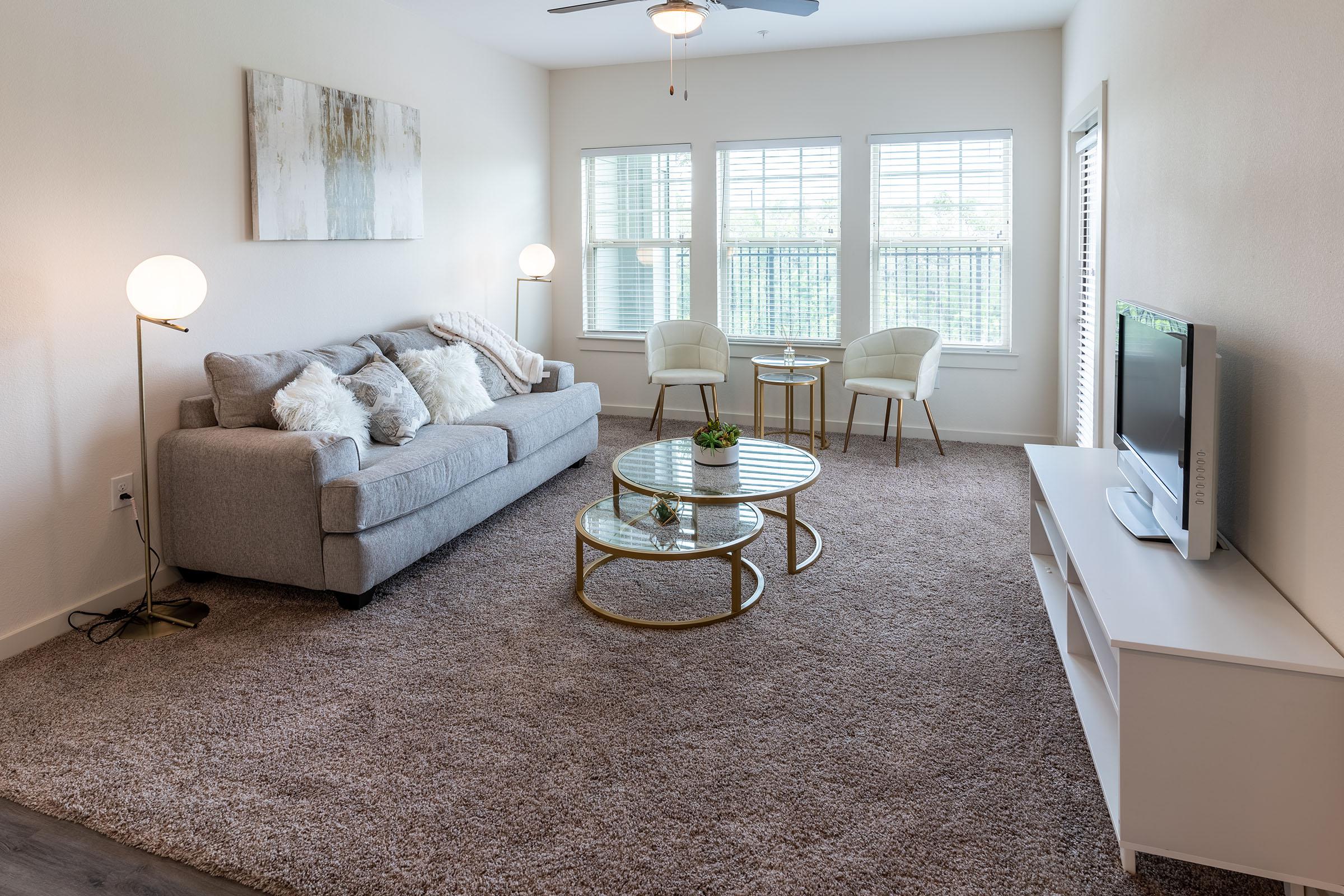 a living room filled with furniture and a large window