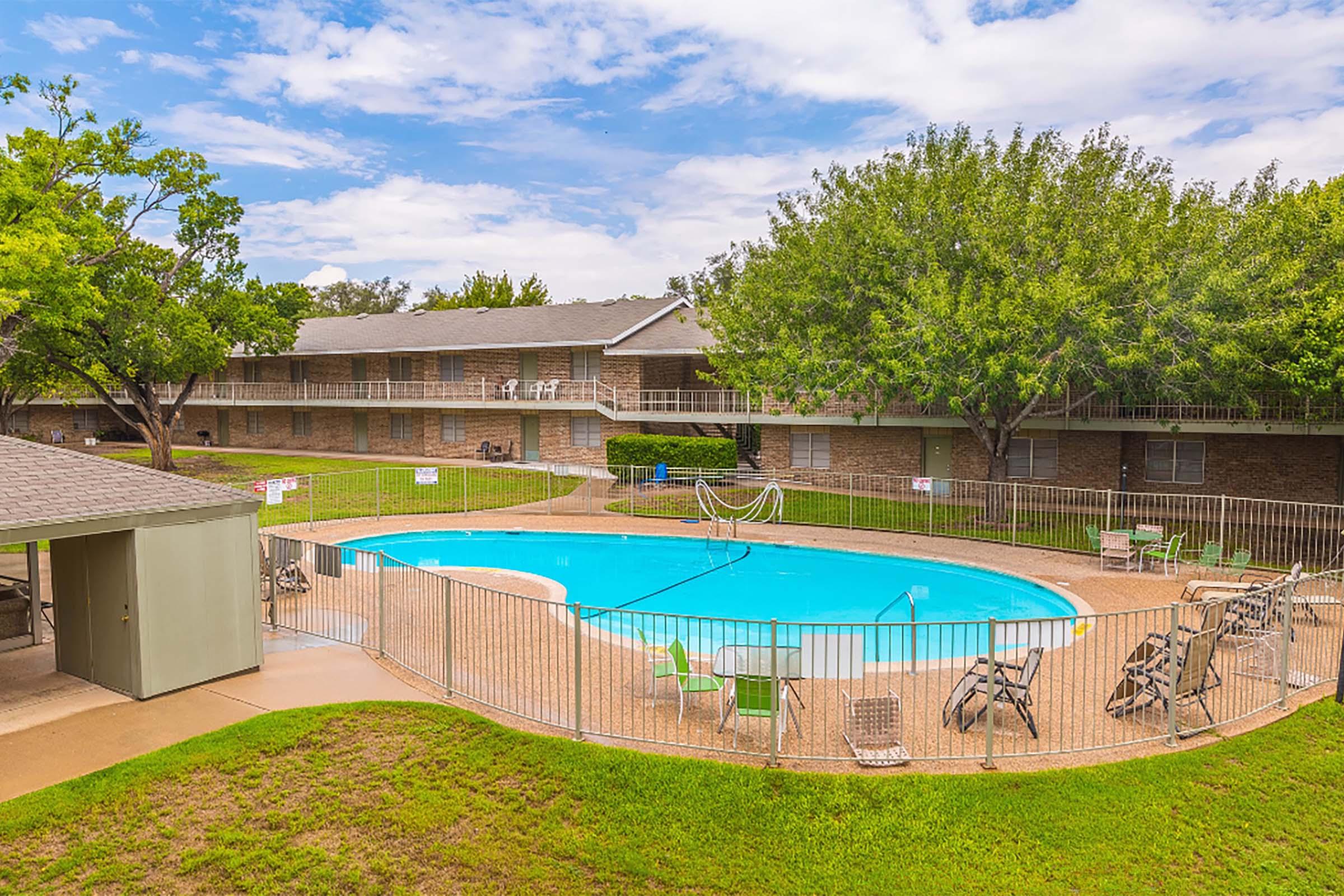 a large lawn in front of a pool