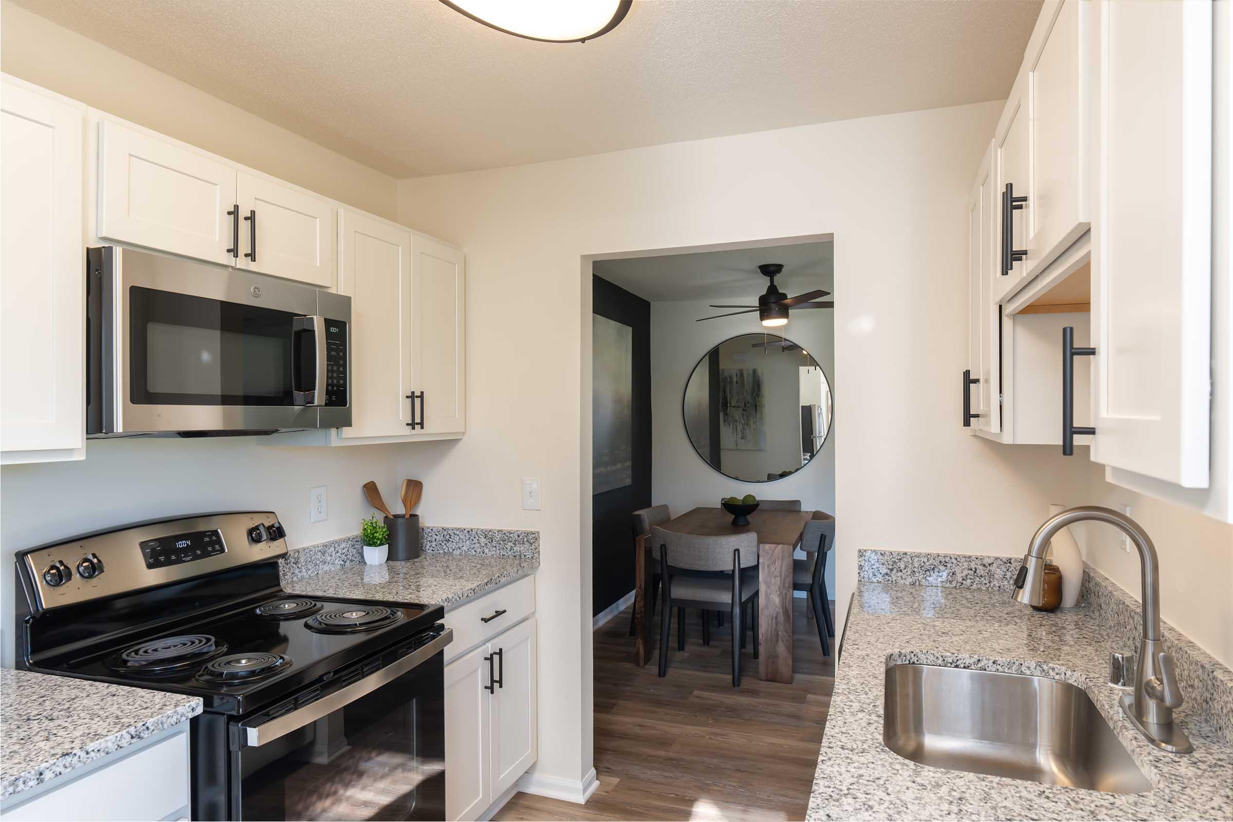 a kitchen with a stove a sink and a microwave