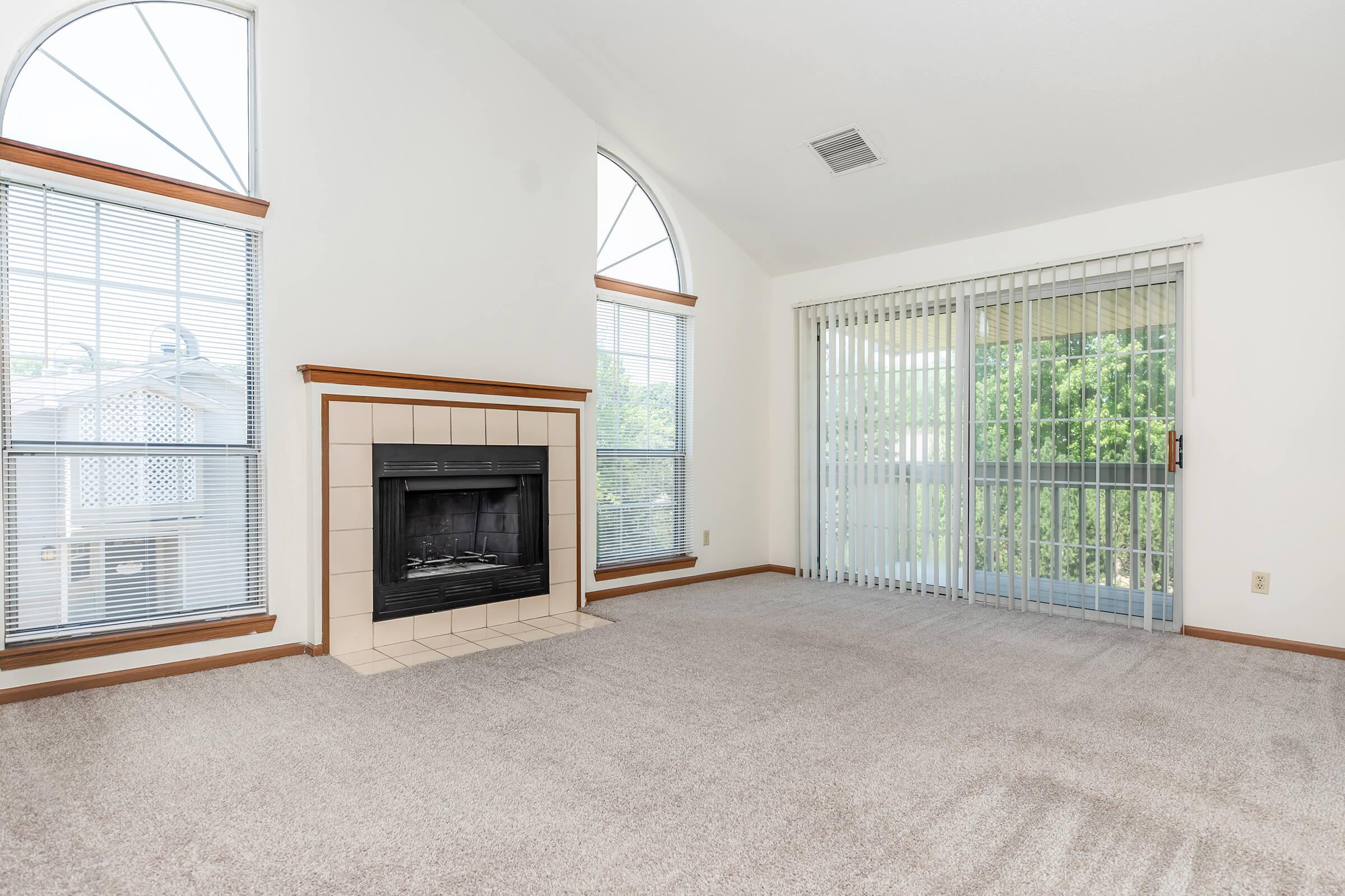 a living room with a fireplace and a large window