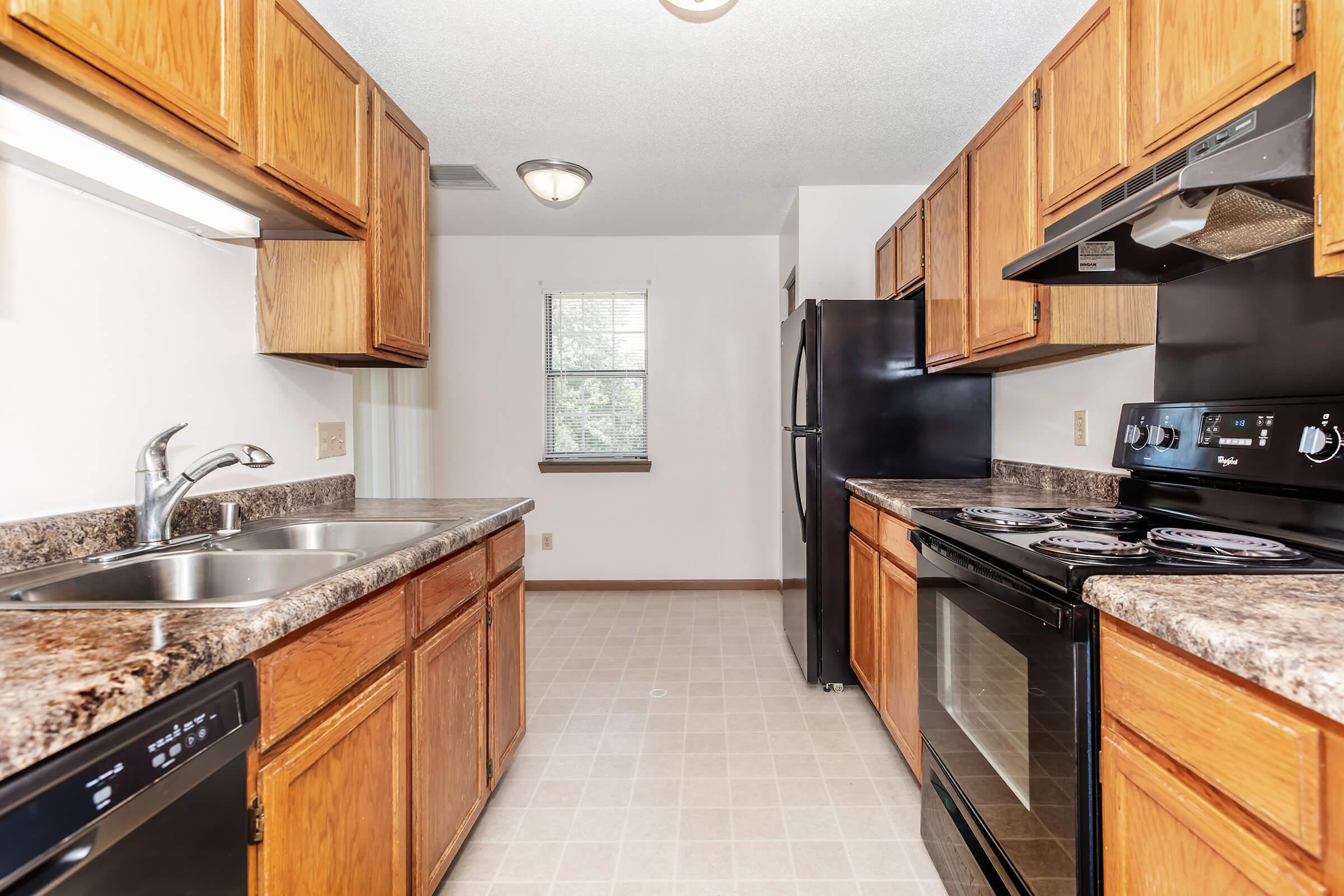 a large kitchen with stainless steel appliances and wooden cabinets