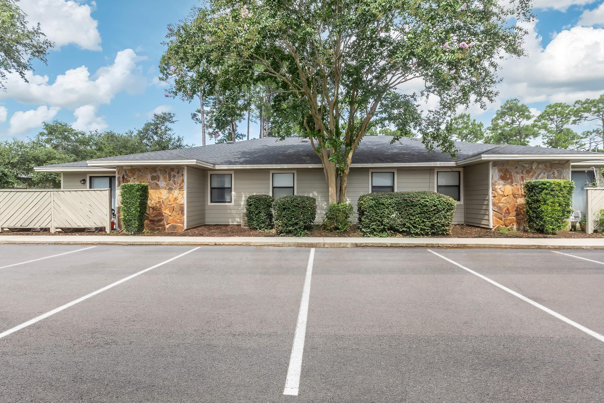 an empty parking lot in front of a house