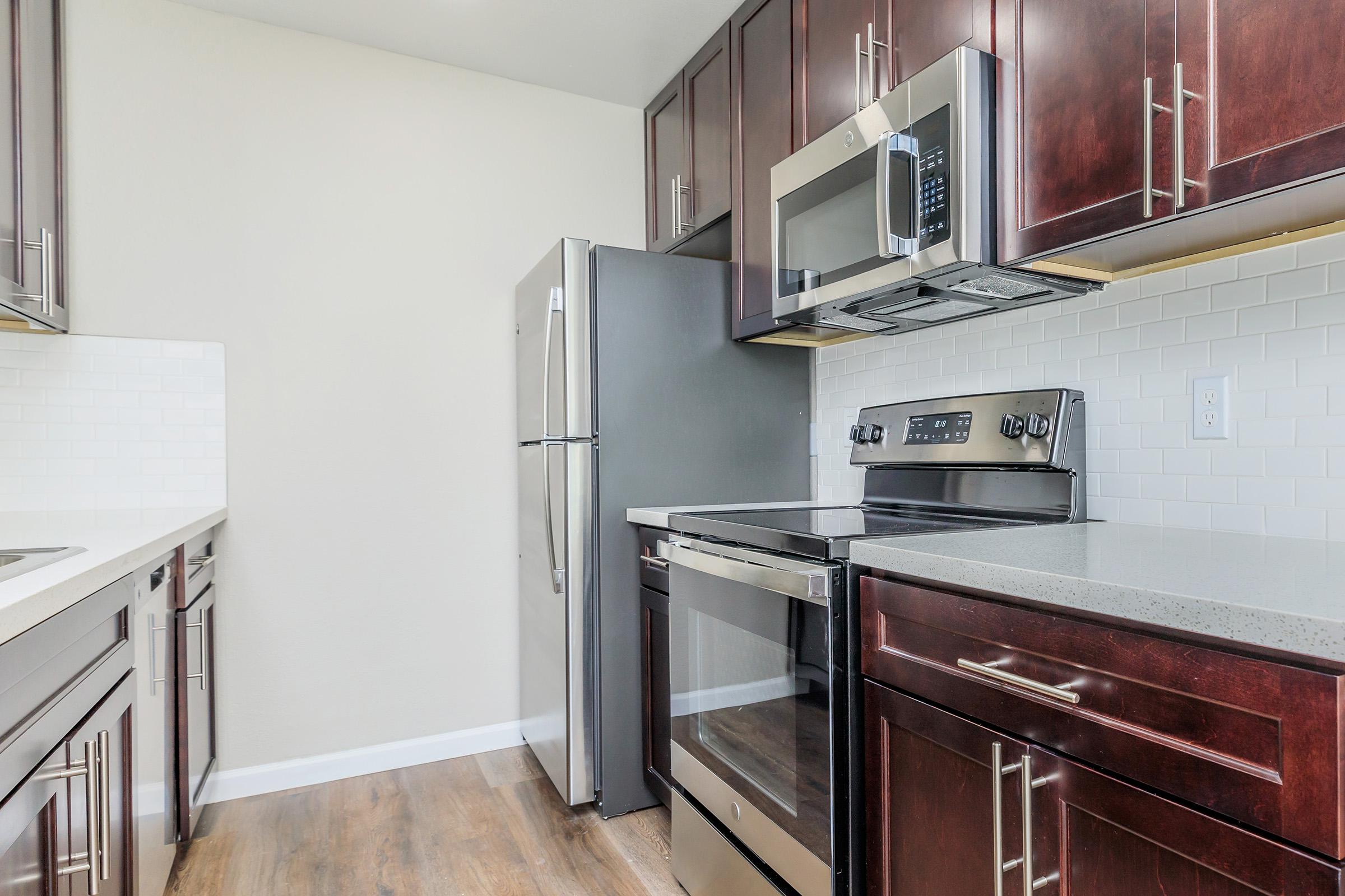 a kitchen with stainless steel appliances and wooden cabinets