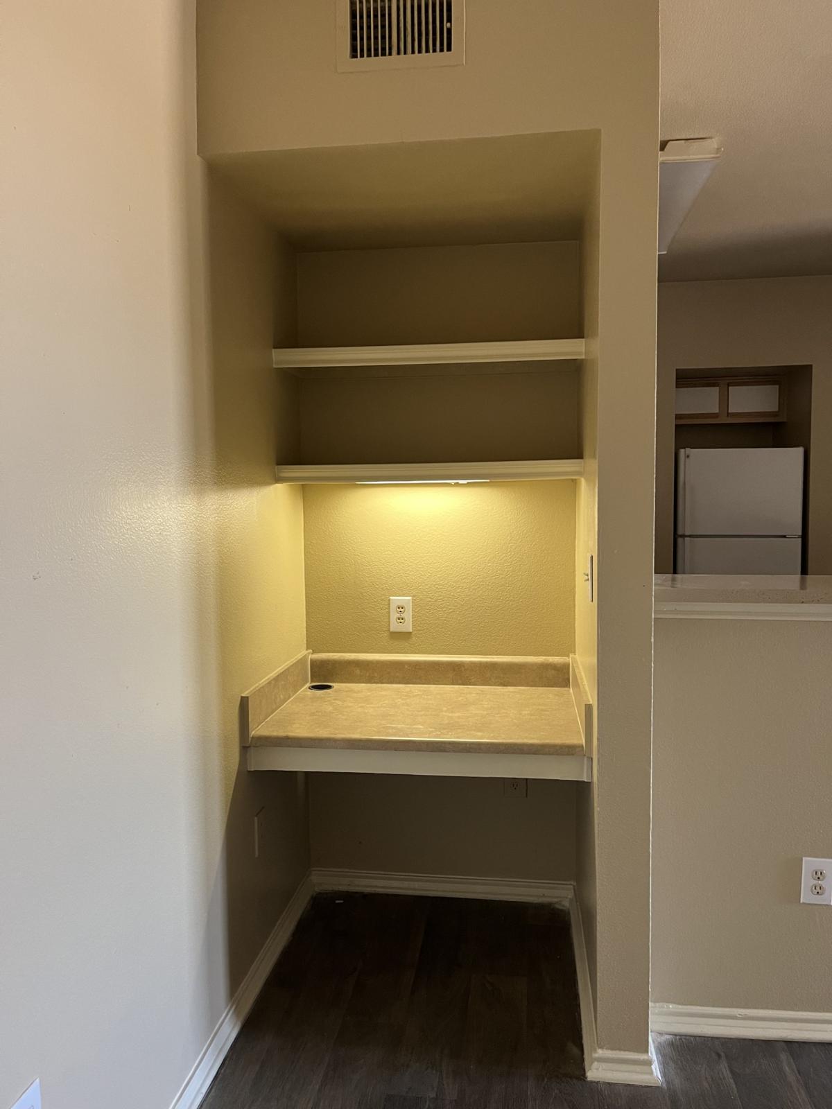 Discover your perfect workspace with this inviting nook, featuring built-in shelves and soft lighting, ideal for productivity and creativity in the comfort of your own home.