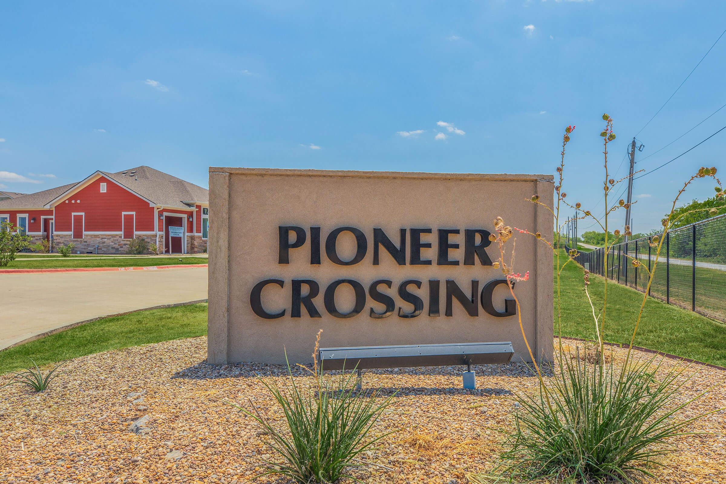 a sign on the side of a dirt field