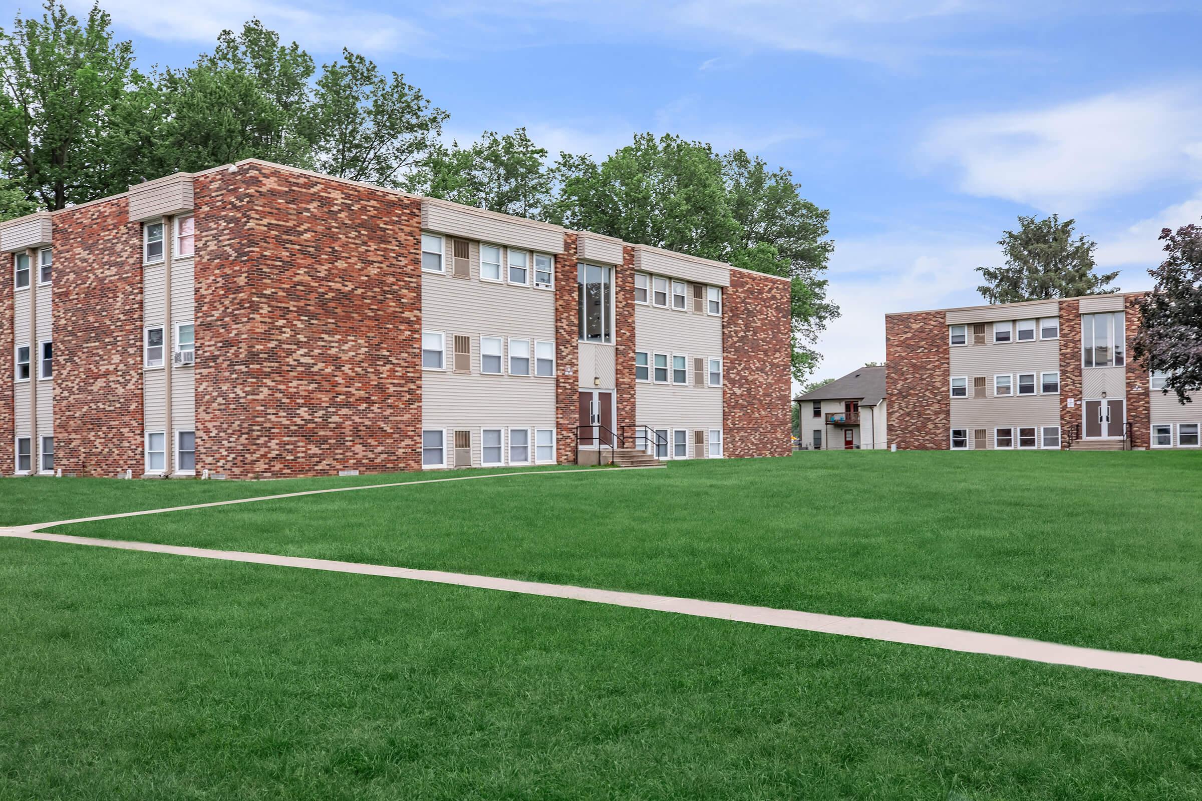 a large brick building with a grassy field with US Grant Boyhood Home in the background