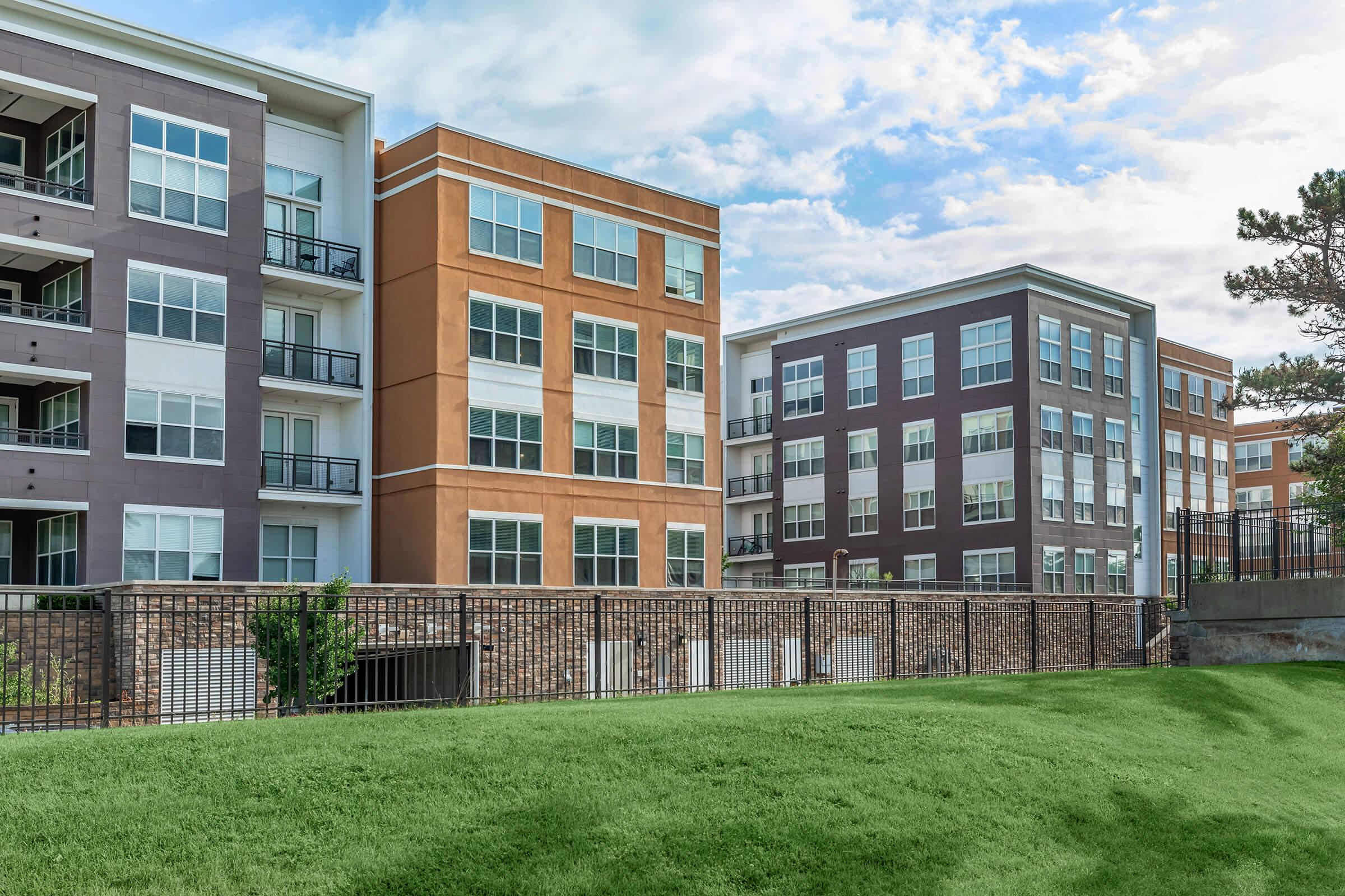 a large brick building with a grassy field