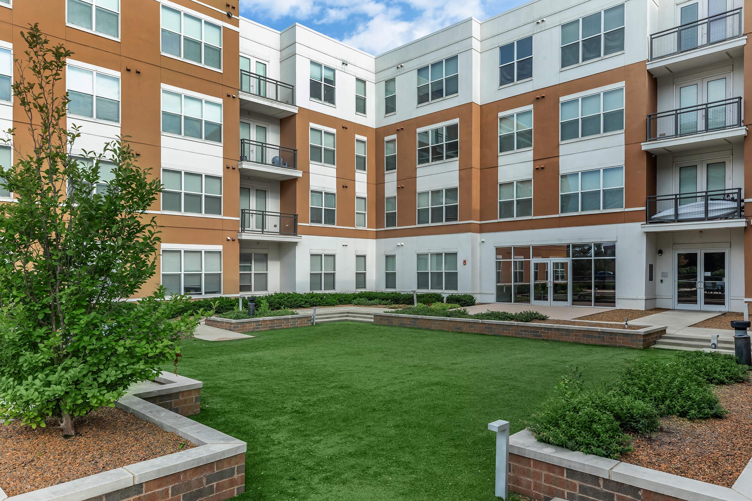 a garden in front of a brick building