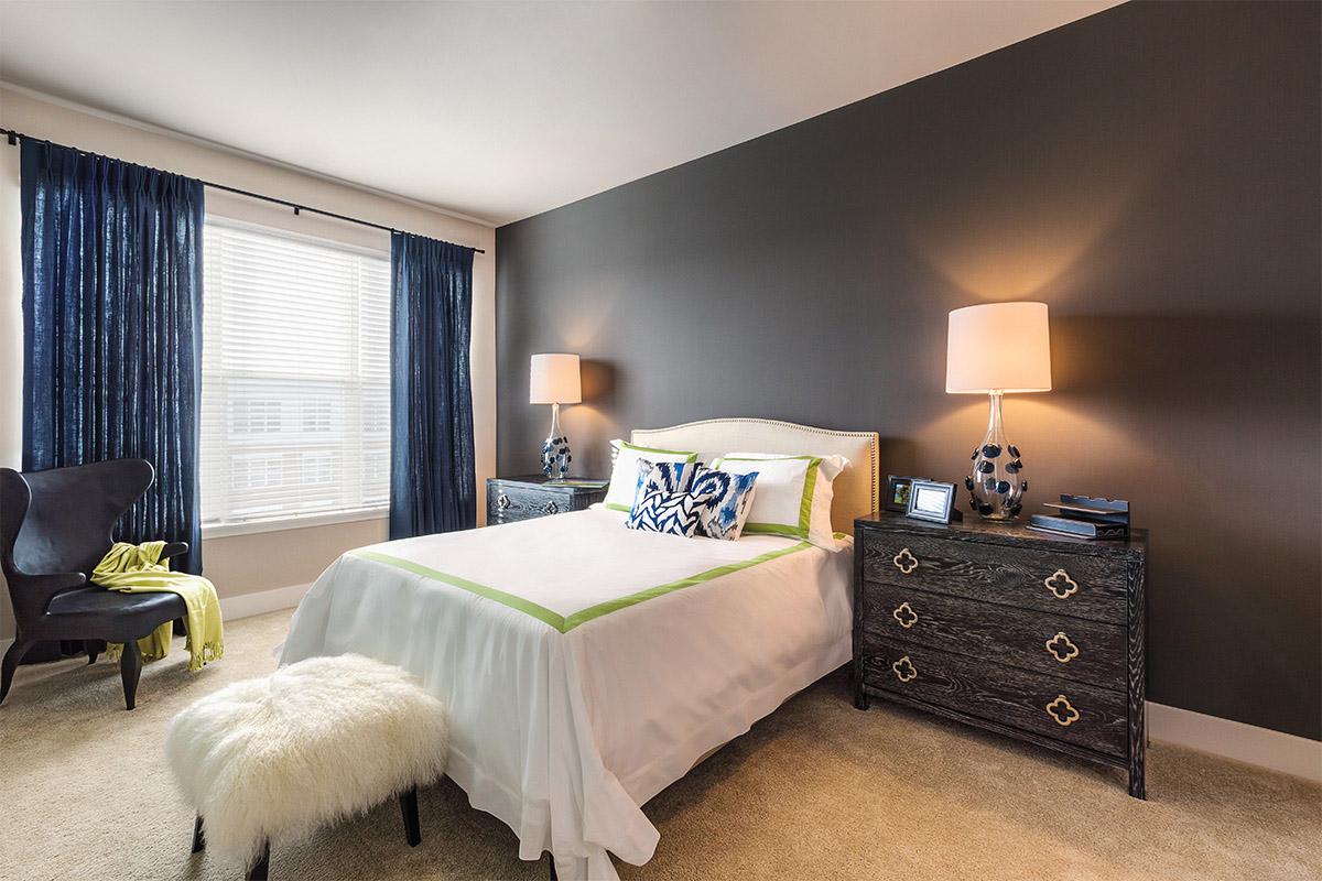 a bedroom with a bed and desk in a hotel room