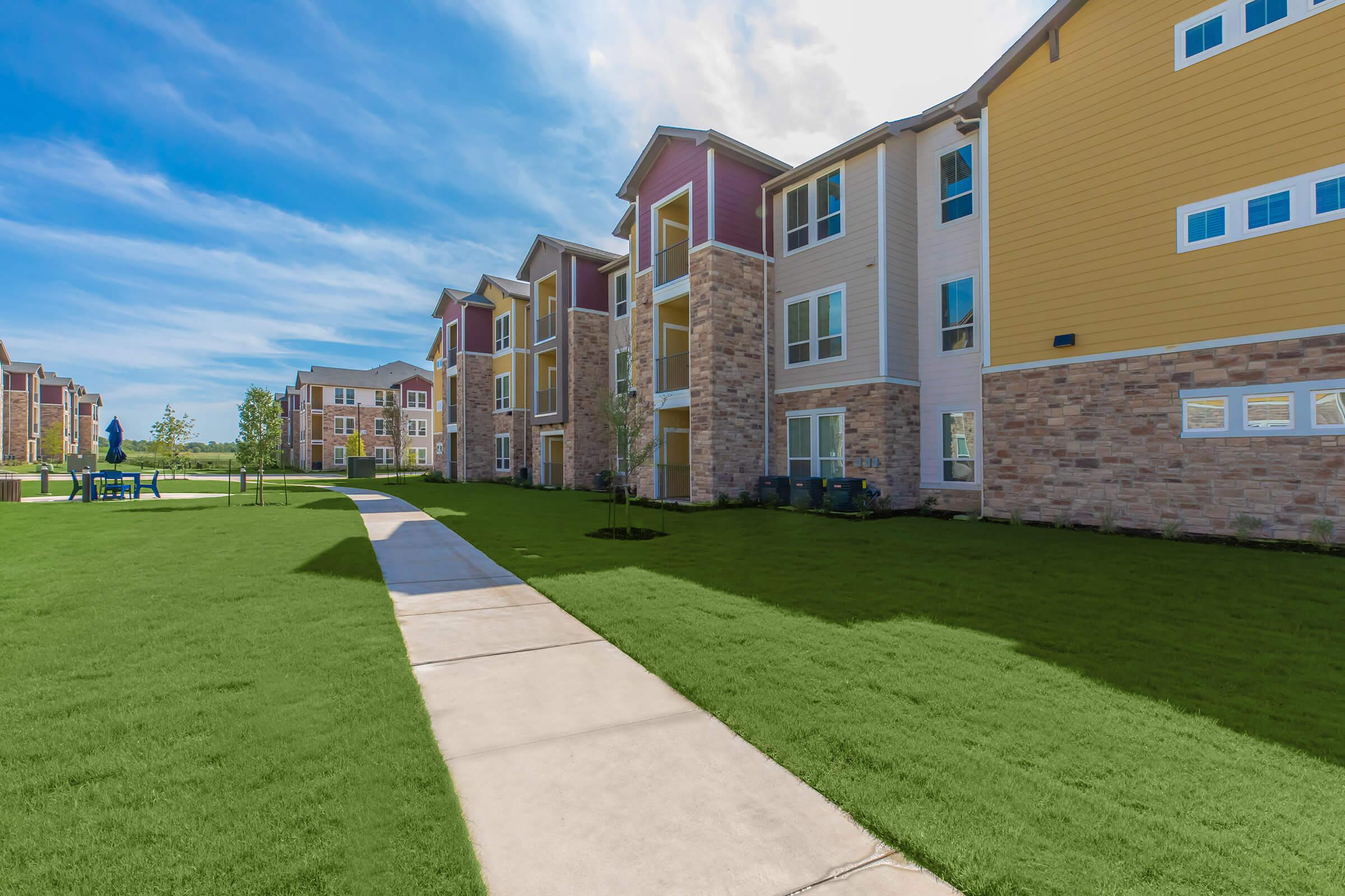 a large brick building with green grass