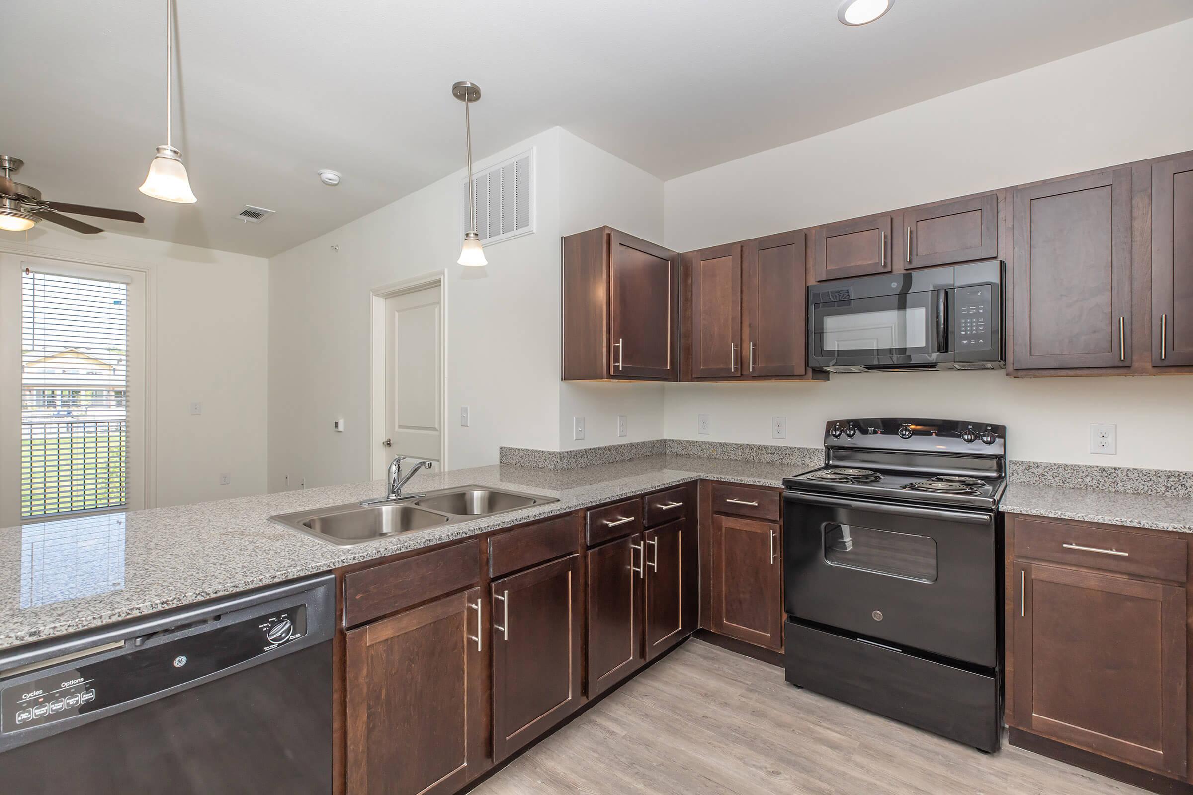 a large kitchen with stainless steel appliances and wooden cabinets