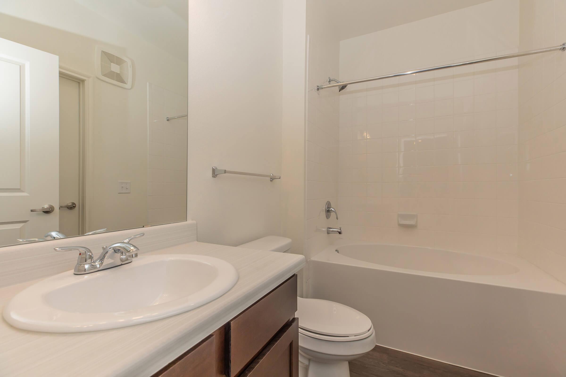 a white sink sitting under a mirror