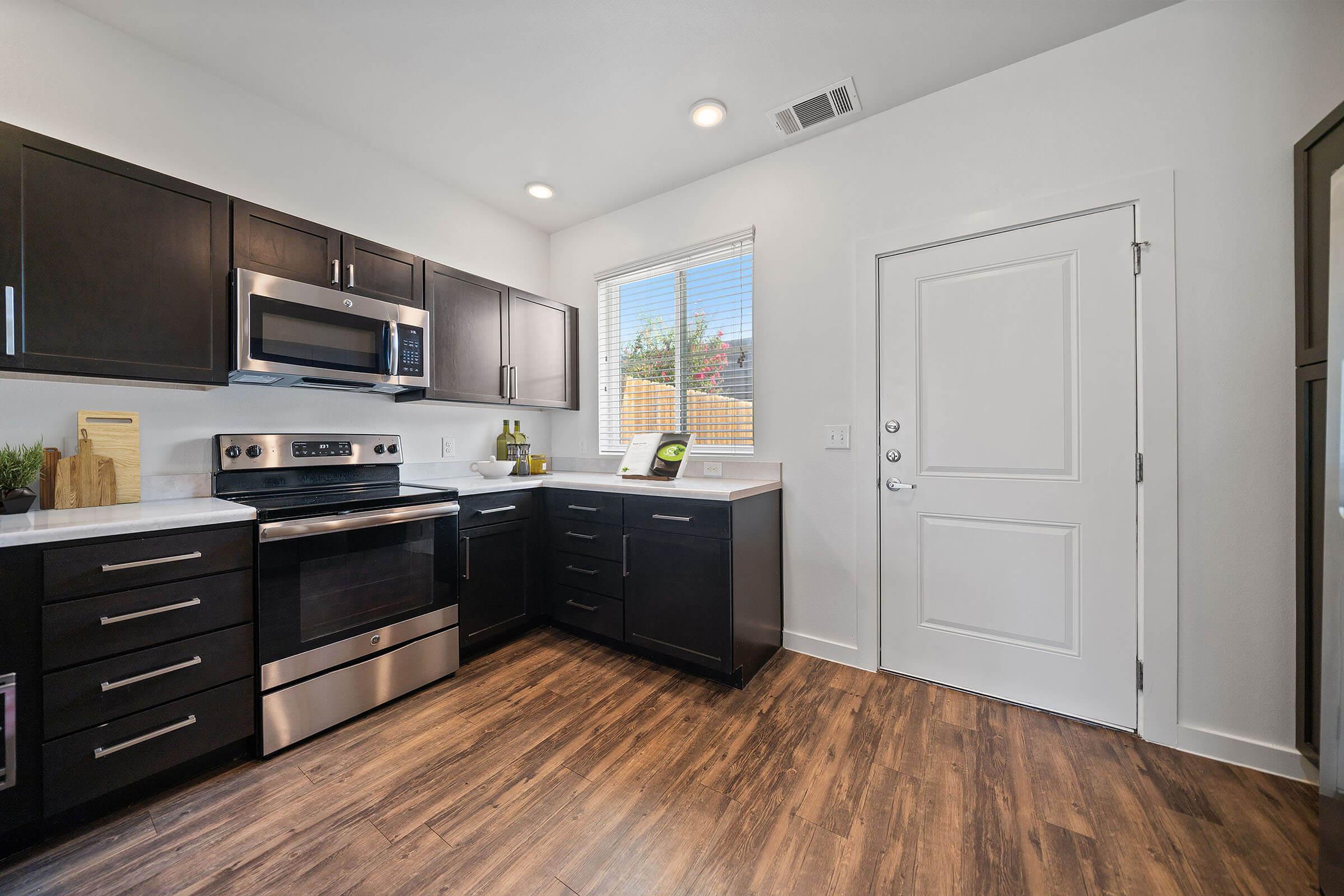 a large kitchen with stainless steel appliances and wooden cabinets