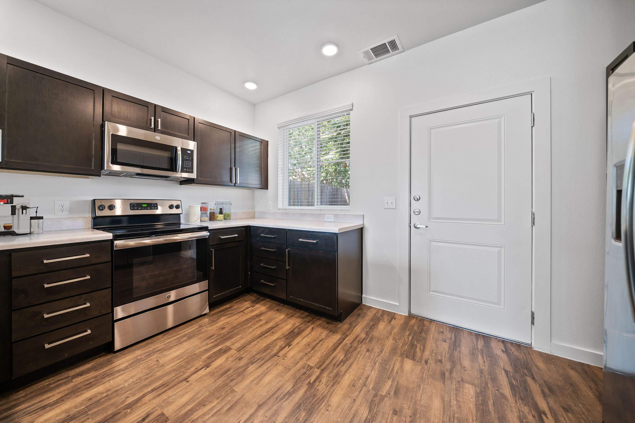 a modern kitchen with stainless steel appliances and wooden cabinets