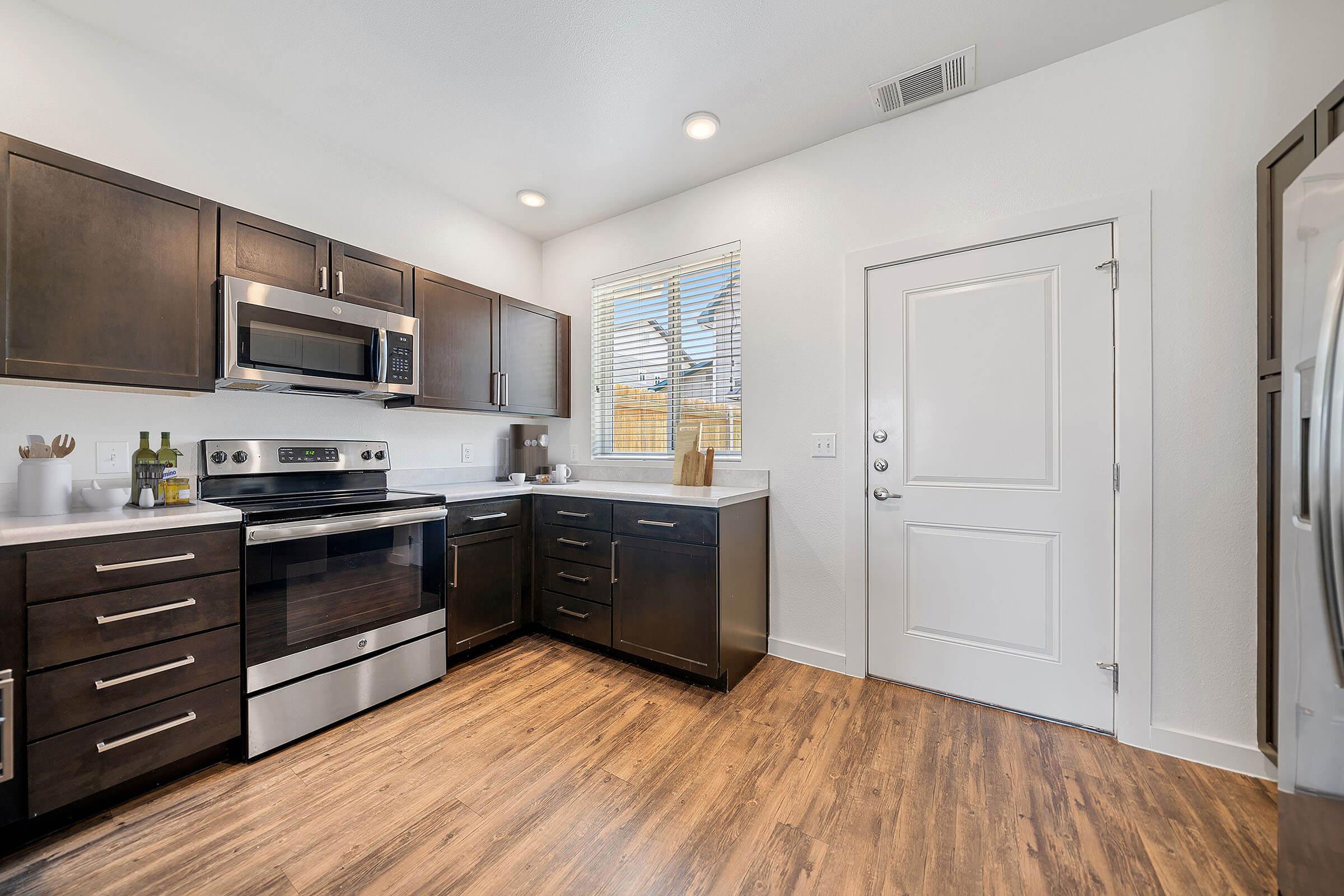 a large kitchen with stainless steel appliances and wooden cabinets