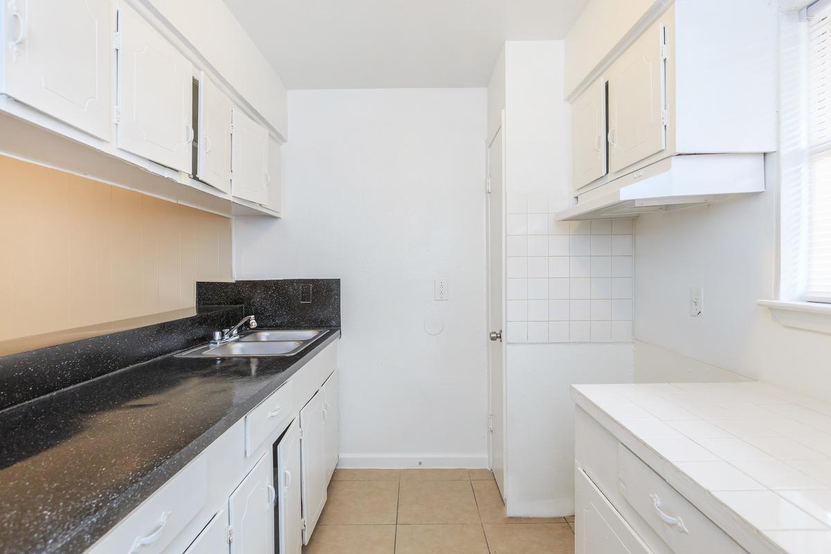 Unfurnished kitchen with black countertops