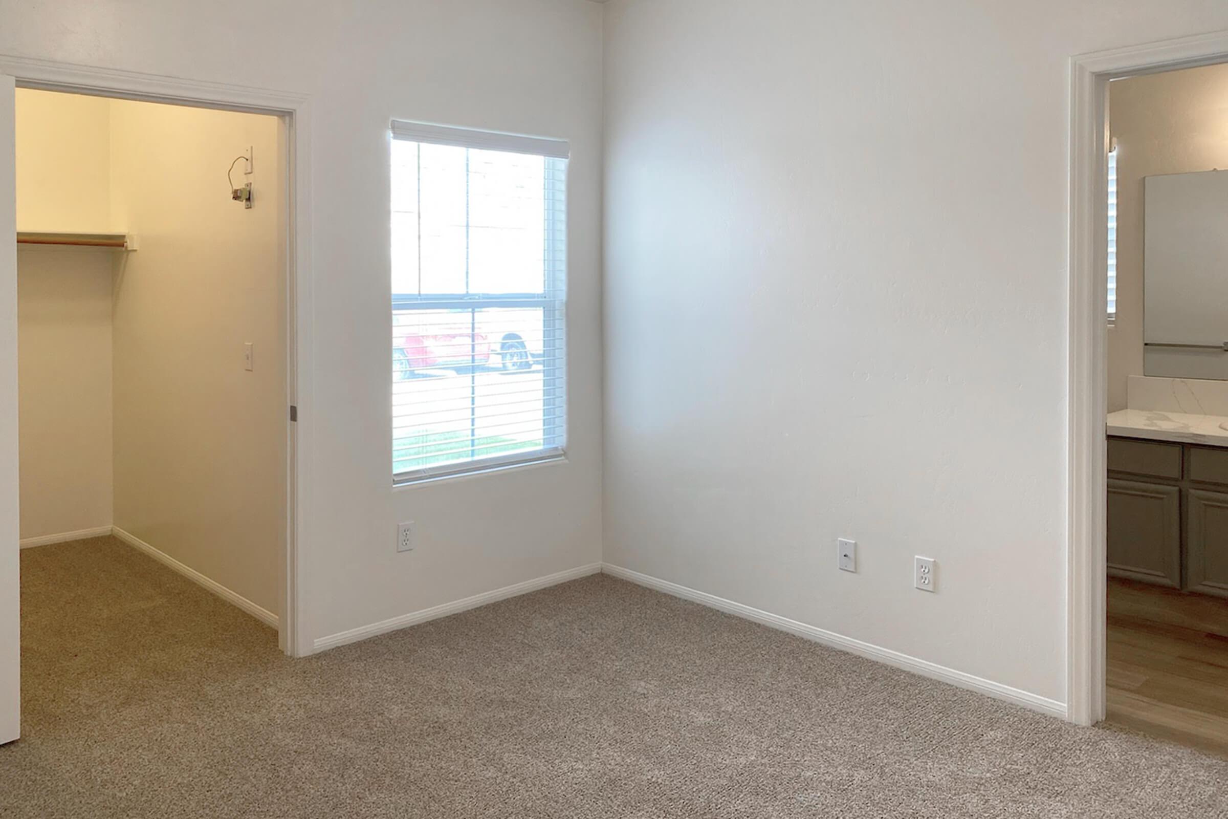 vacant carpeted bedroom with walk-in closet