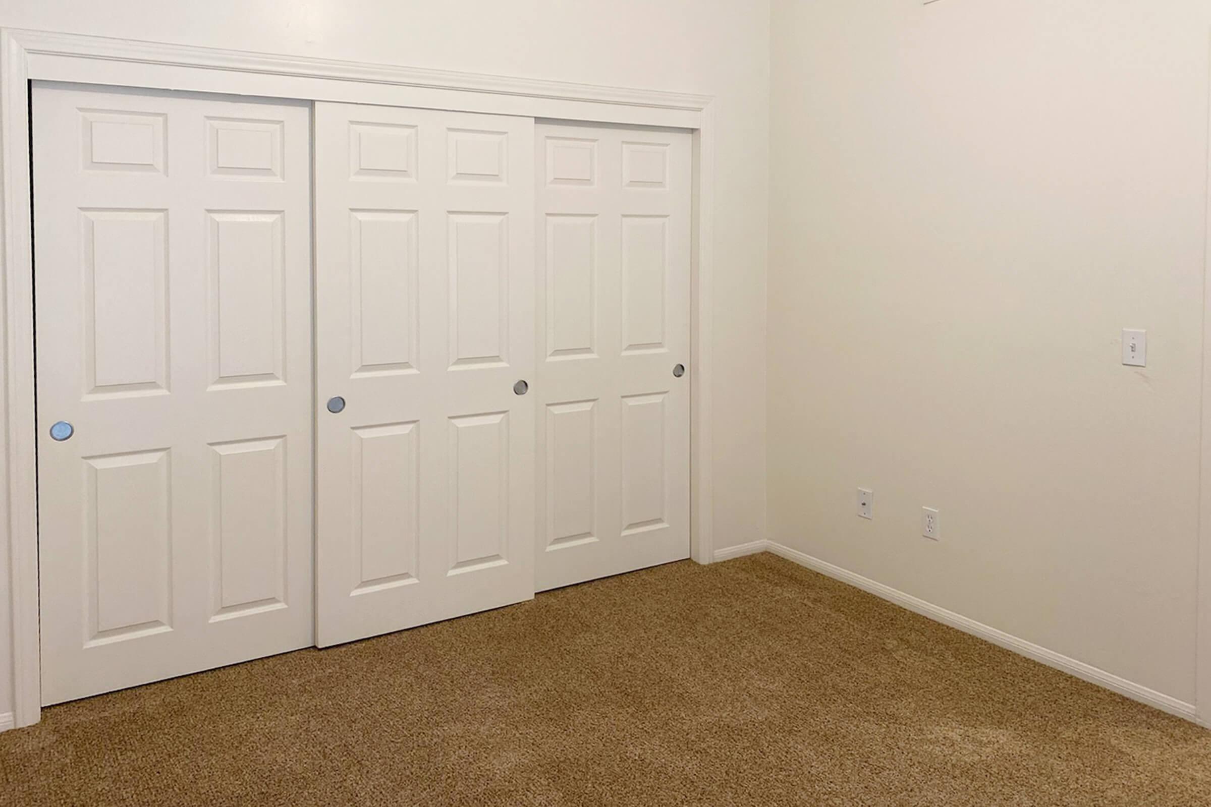 vacant bedroom with carpet and closed closet doors