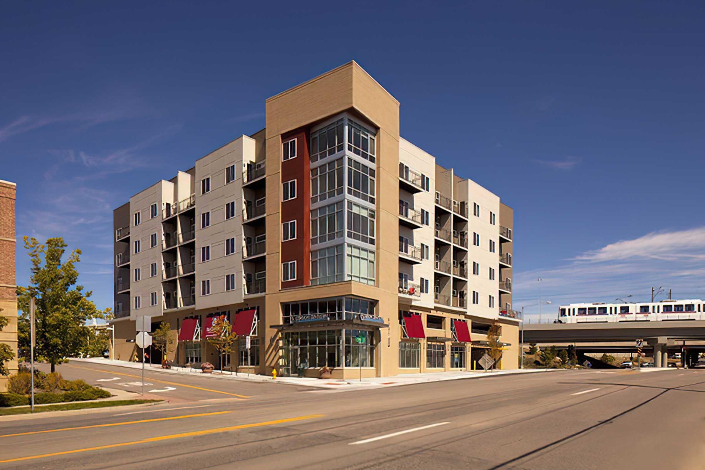Modern multi-story building featuring a mix of residential and commercial spaces, with large windows and a contemporary facade.
