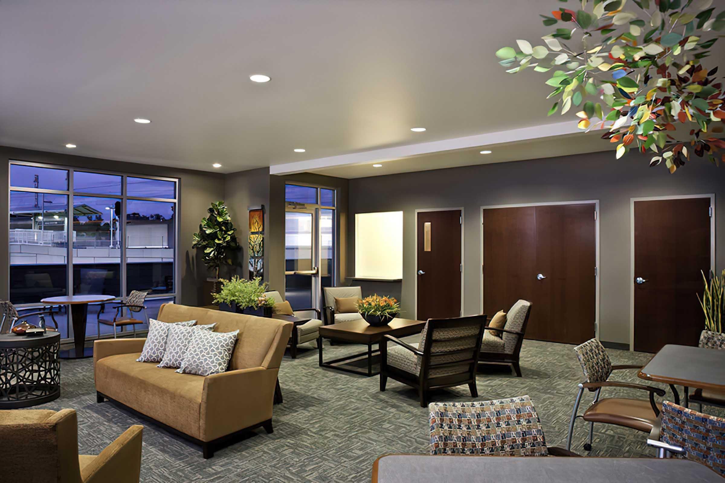 A modern lounge area featuring comfortable seating, tables, and decorative plants