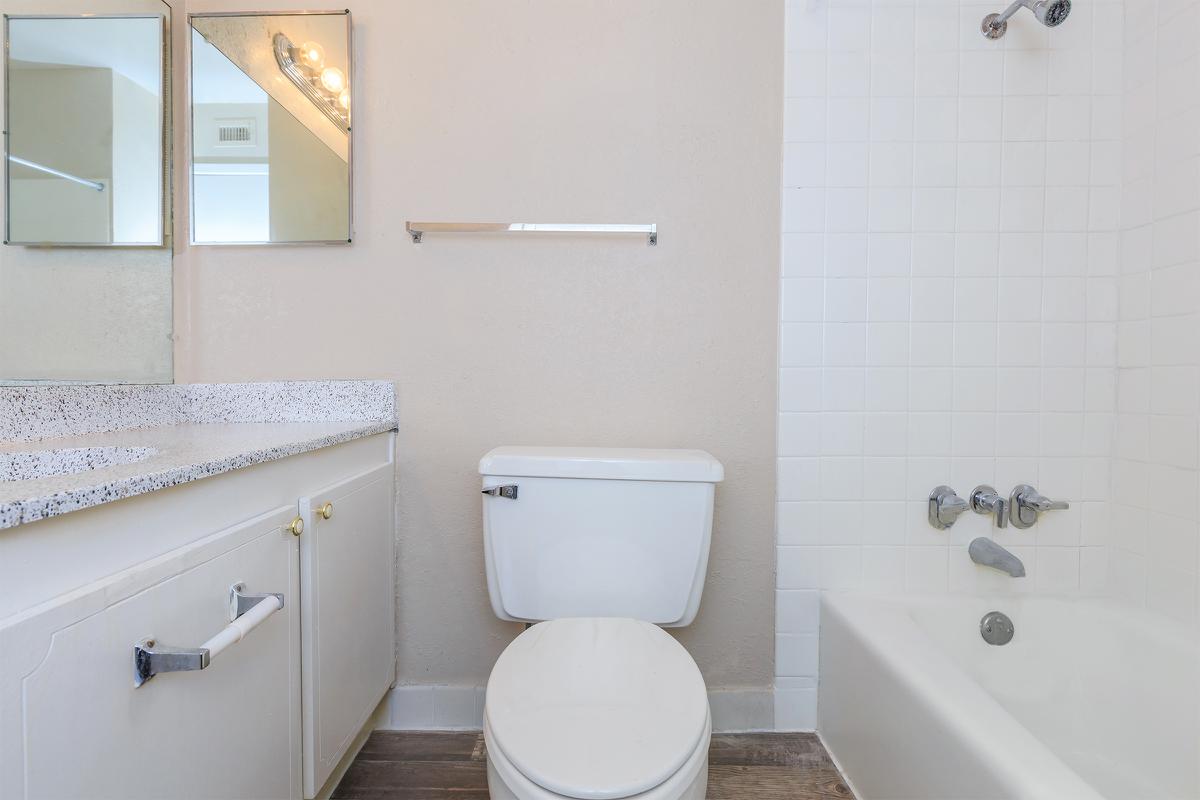 a white sink sitting under a mirror