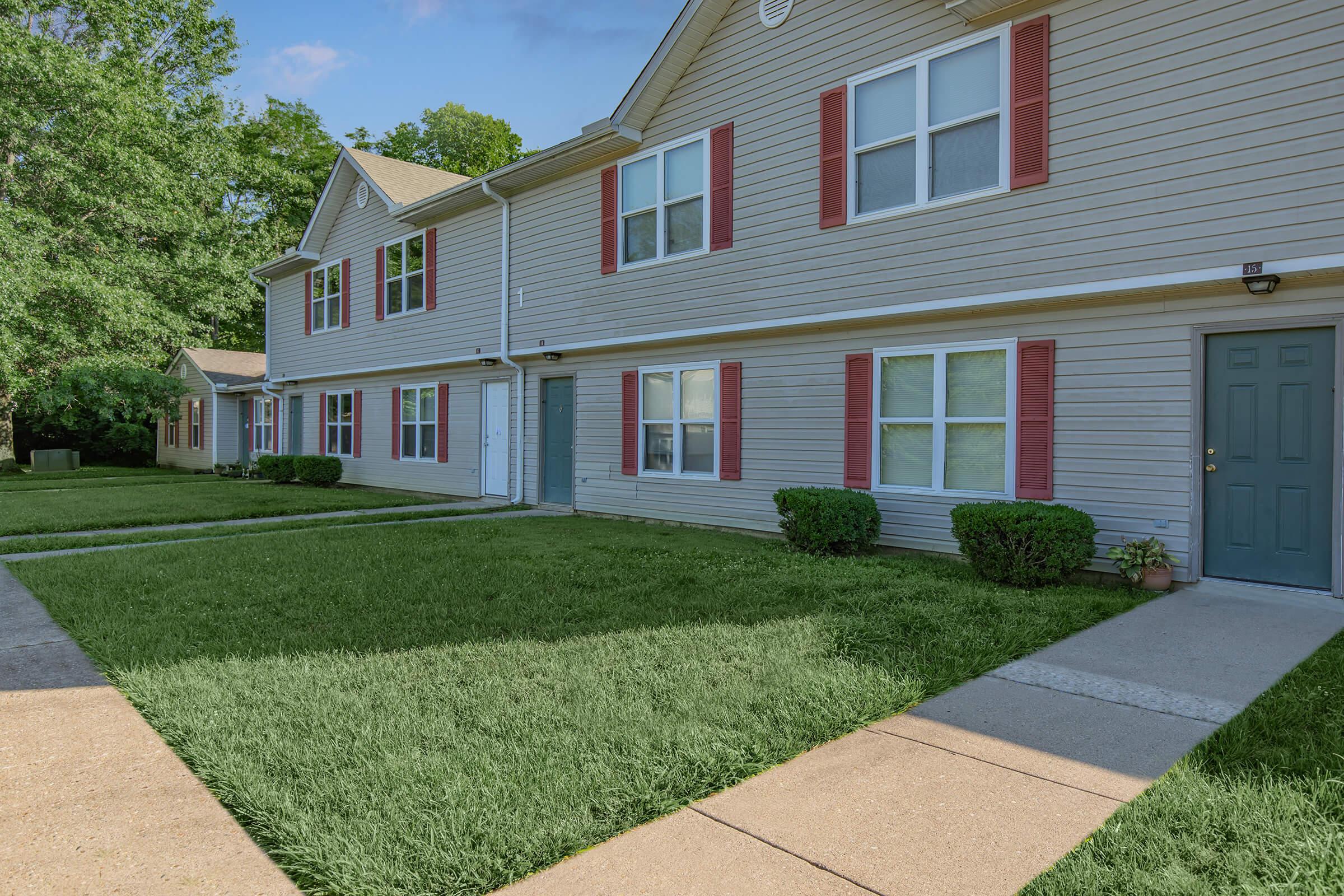 a large brick building with grass in front of a house