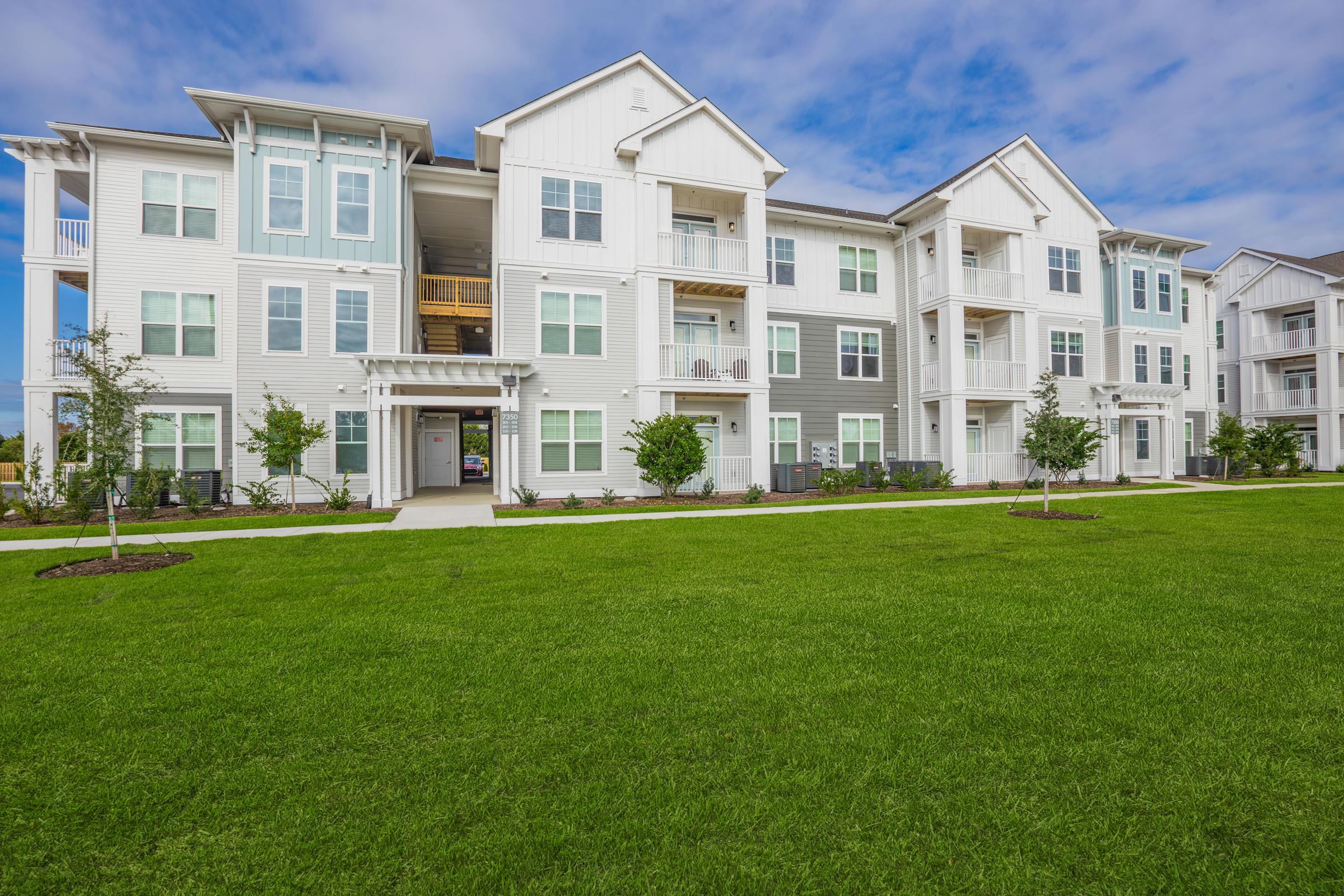 a large green field in front of a building