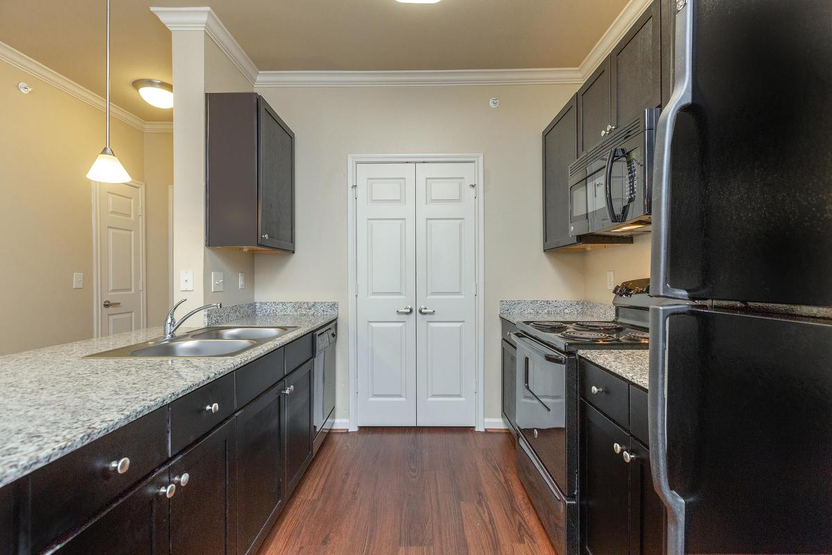 a large kitchen with stainless steel appliances and wooden cabinets