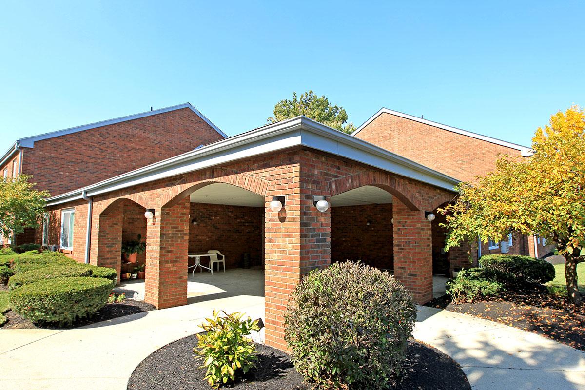 a small house in front of a brick building