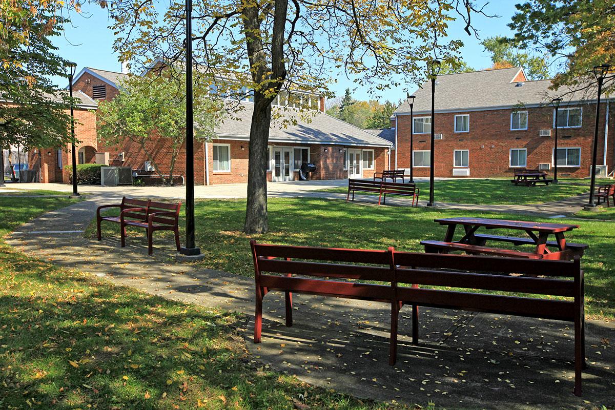 an empty park bench next to a fence