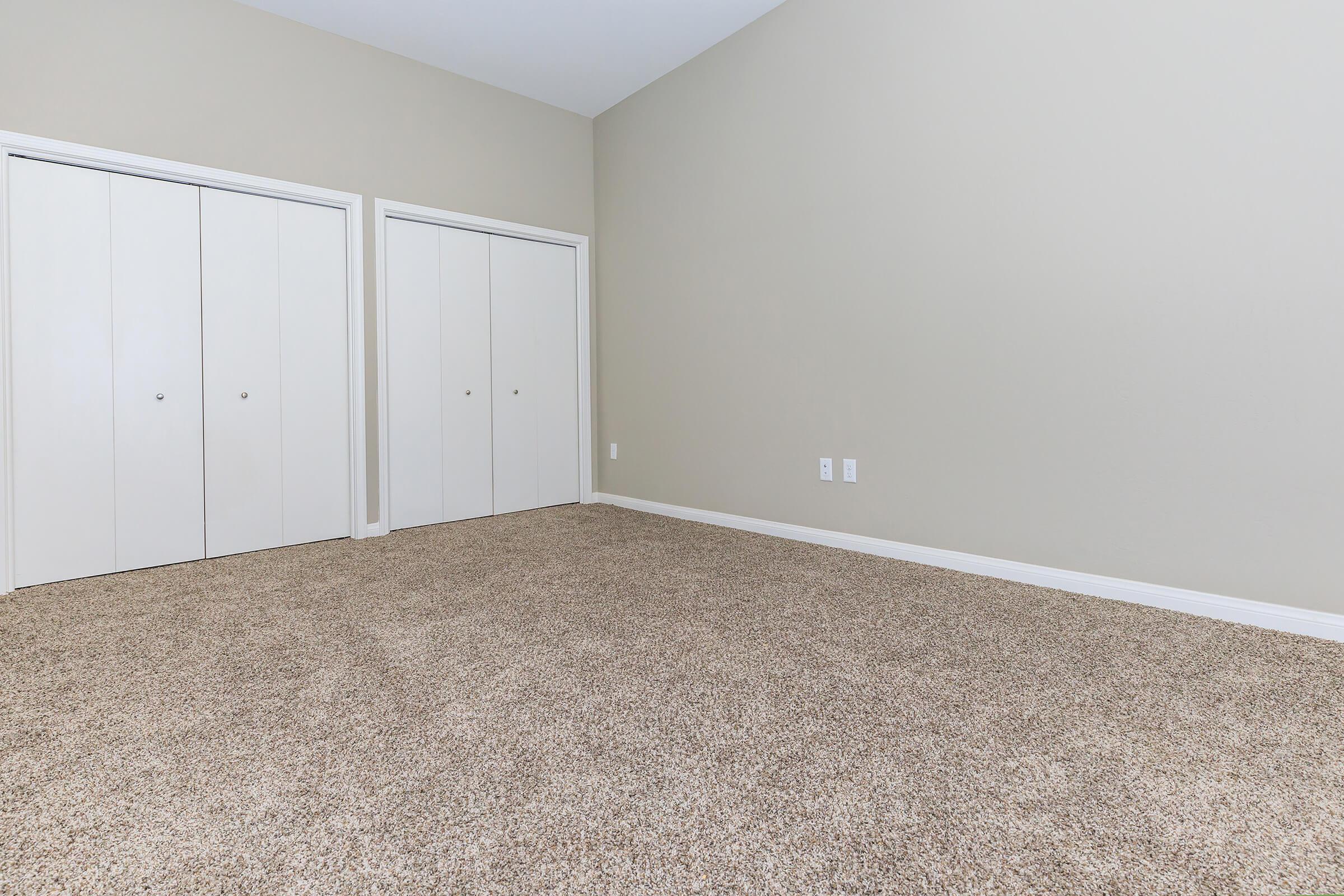 Bedroom with two sets of closed closet doors