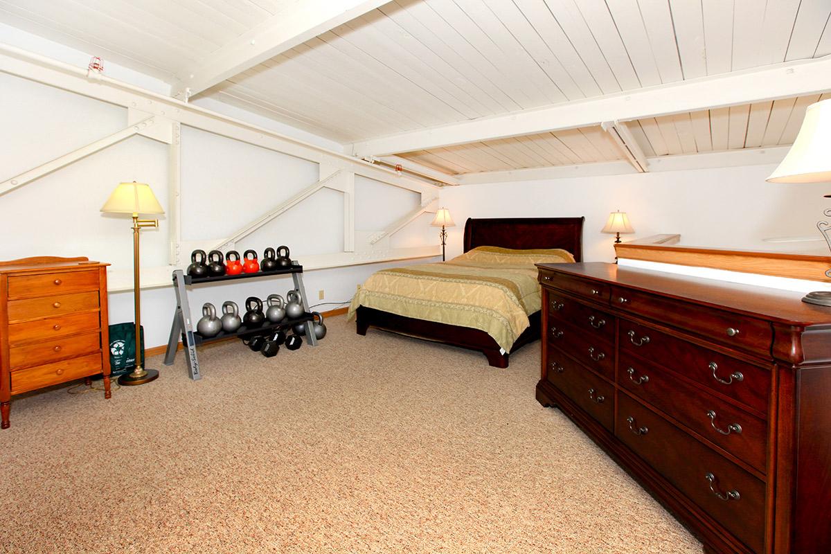 a bedroom with a bed and desk in a room