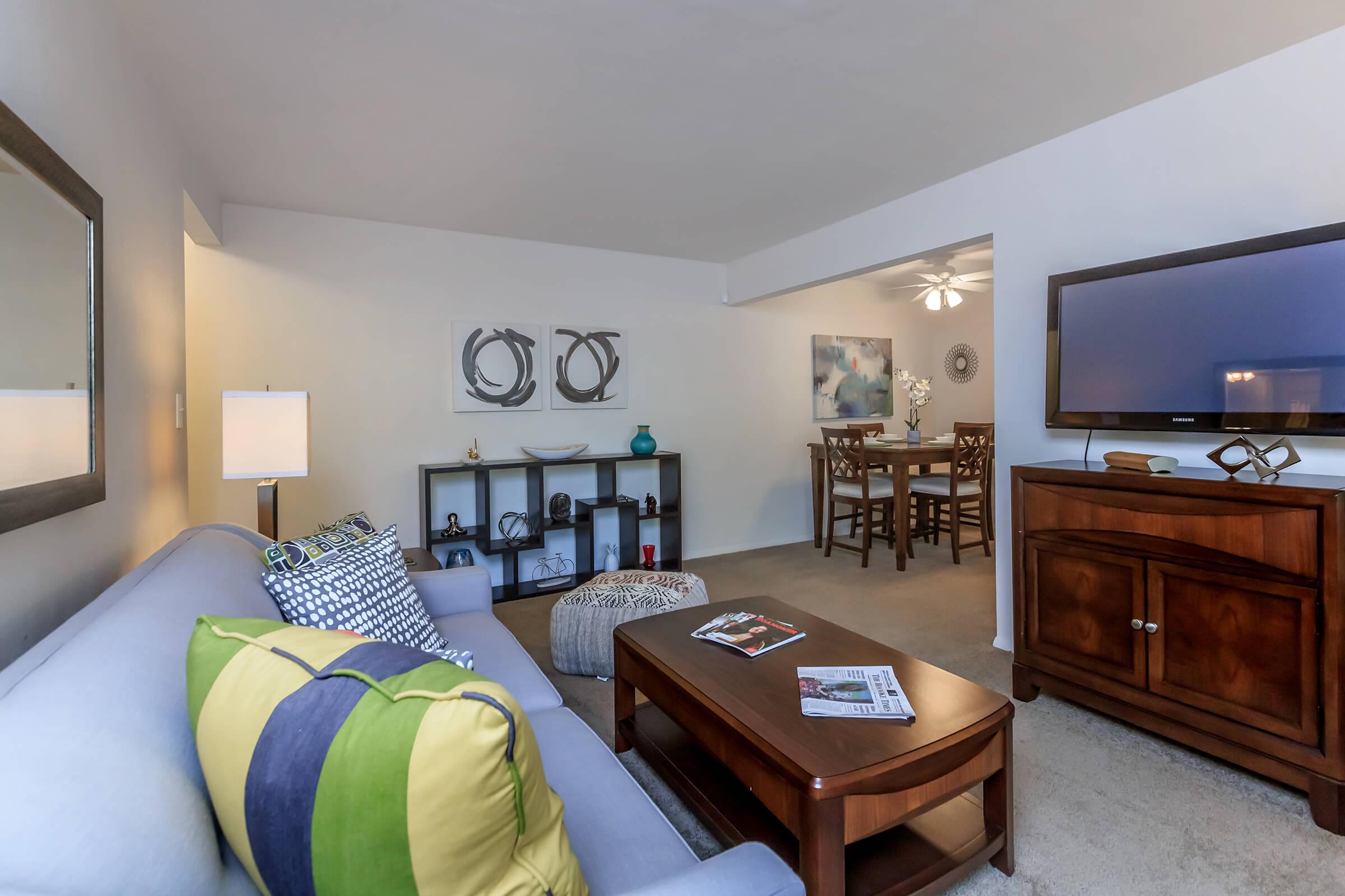 a living room filled with furniture and a flat screen tv