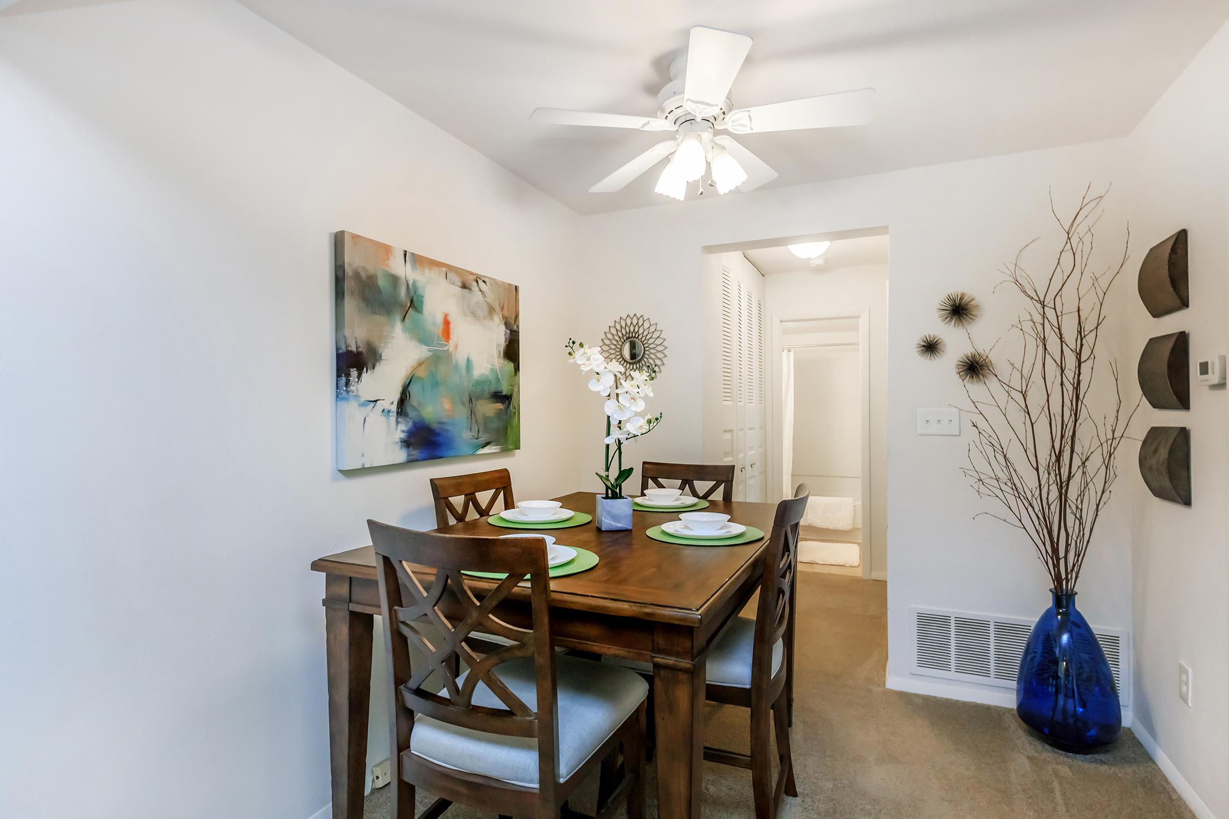 a room filled with furniture and vase of flowers on a table