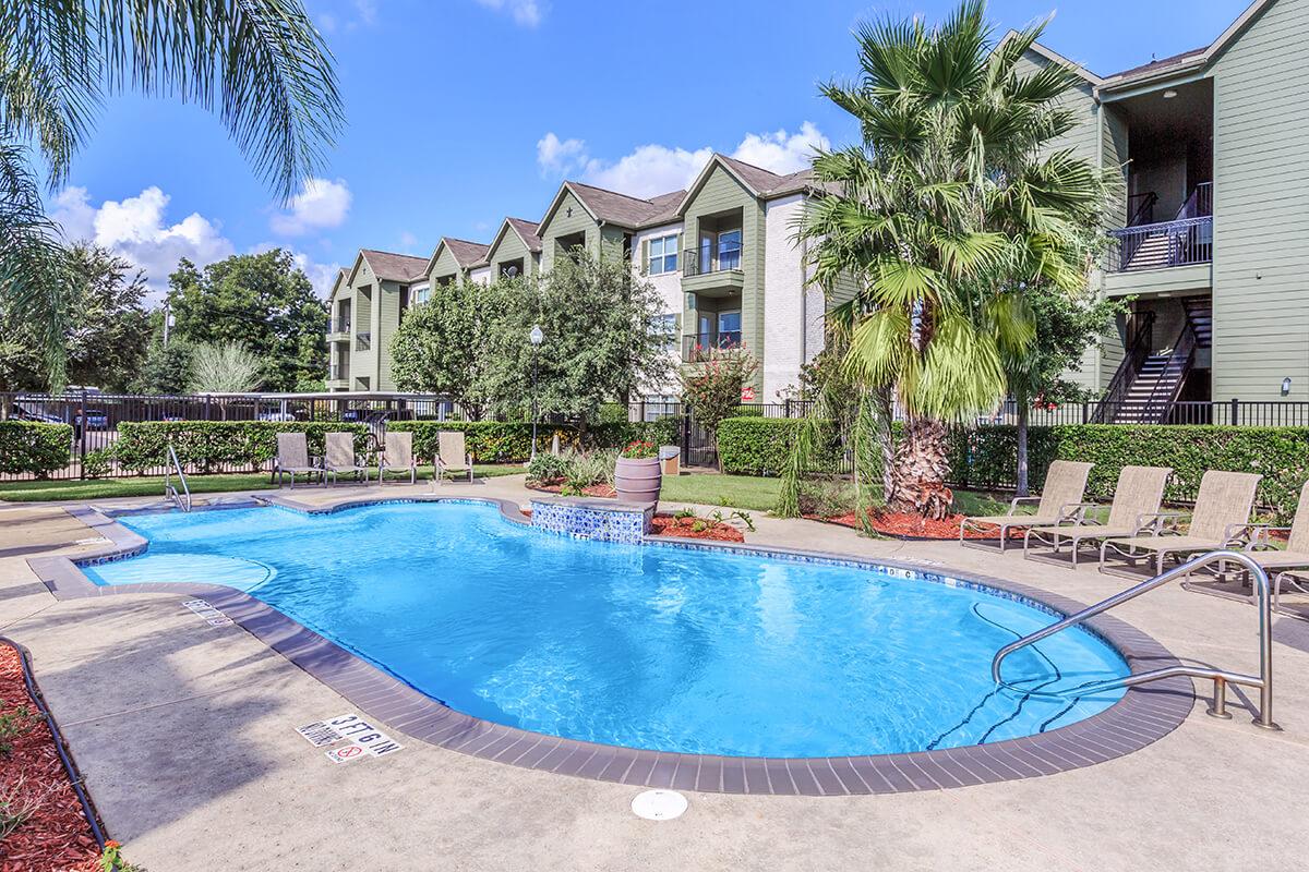 Shimmering outdoor swimming pool with lounge chairs at The Avenue apartments 