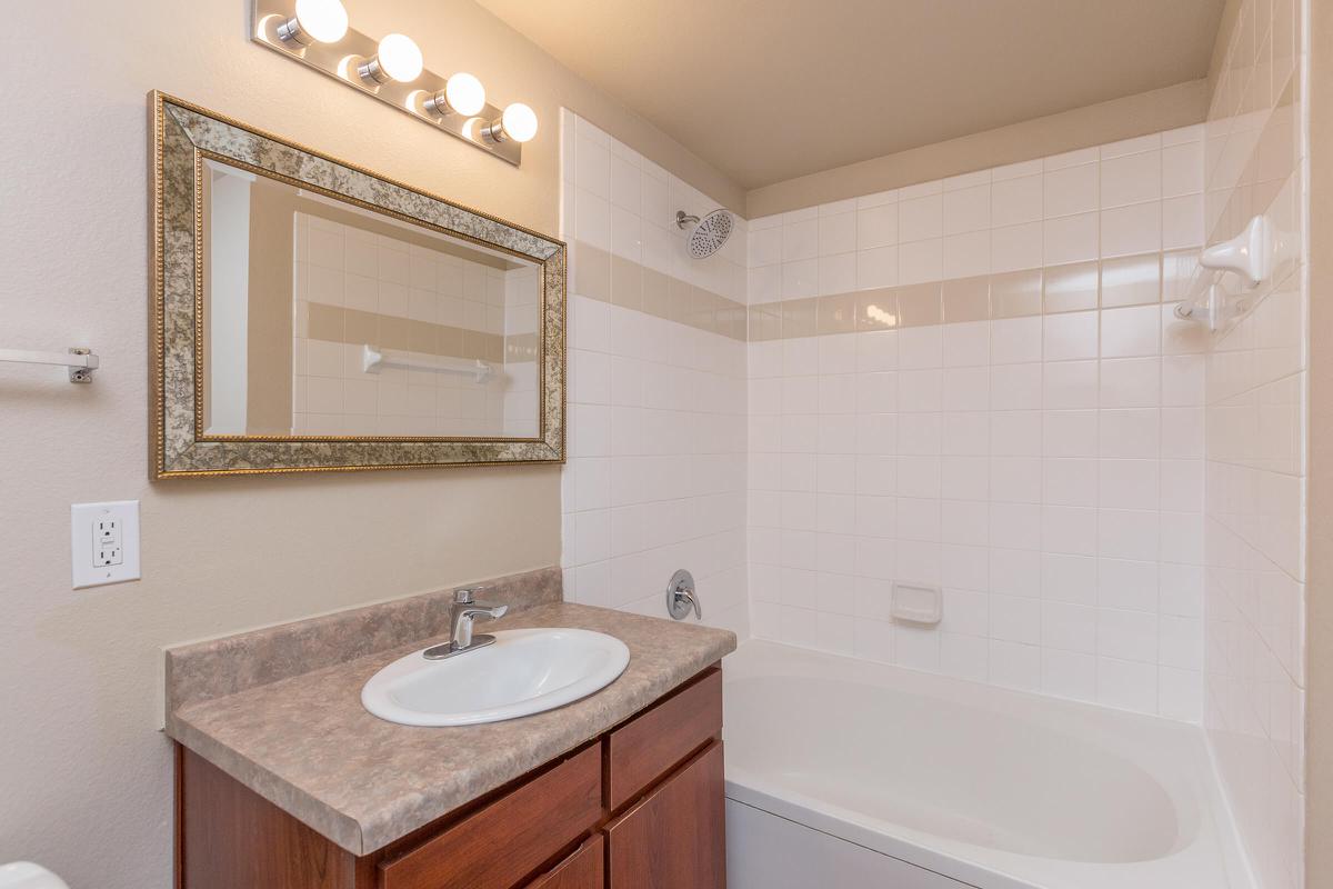 a white sink sitting under a mirror